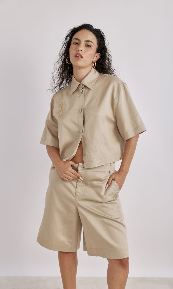 חולצה גזרת קרופ מכופתרת בעיטור אטב מוזהב הרכב: 56% ליוסל, 26% פשתן, 18% כותנההדוגמנית בגובה 1.78 ולובשת מידה 40 של MOSCHINO