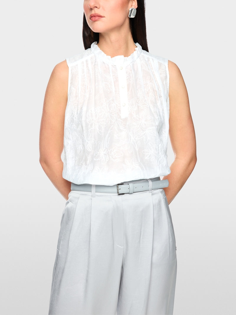 חולצה אלגנטית ללא שרוולים בגזרה רחבה, עשויה בד מעט שקפקף, מתערובת כותנה ומשי רכה וקלילה, עם דוגמת רקמה פרחונית עדינה. קפלים מודגשים בחזית ובגב, וצווארון קולר בגימור מסולסל עם סגירת 3 כפתורים.הרכב: 77% כותנה, 23% משיהדוגמנית בגובה 1.79 ולובשת מידה 3 של מארק קיין