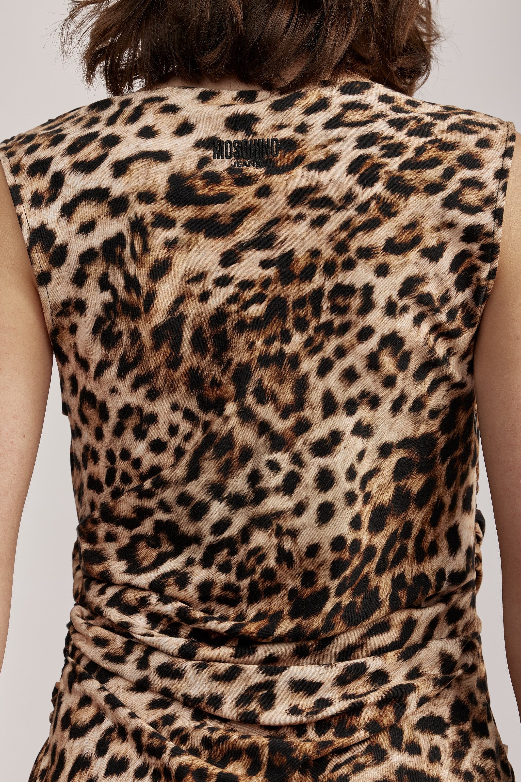 שמלת מקסי מליין MOSCHINO JEANS של המותג האיטלקי מוסקינו.שמלה בעיצוב אלגנטי ונועז, מבד ויסקוזה קליל בהדפס דוגמה מנומרת. ללא שרוולים, עם צווארון סירה, קפלים מכווצים בצד המותן וחצאית מתרחבת יוצרים צללית קלאסית ונשית. לוגו המותג מוטבע בגב השמלה.הרכב: 100% ויסקוזההדוגמנית בגובה 1.75 ולובשת מידה 42 של MOSCHINO