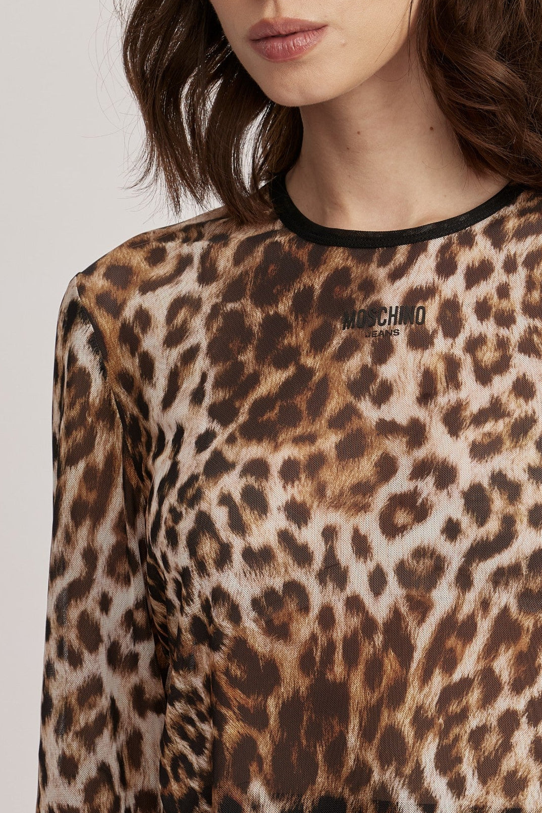 חולצה מליין MOSCHINO JEANS של המותג האיטלקי מוסקינו.החולצה עשויה בד רשת שקפקף בהדפס מנומר, גזרה צמודה לגוף, עם שרוולים ארוכים וצווארון עגול. לוגו המותג מוטבע בחזית.הרכב: 95% פוליאסטר, 5% אלסטןהדוגמנית בגובה 1.75 ולובשת מידה 42 של MOSCHINO