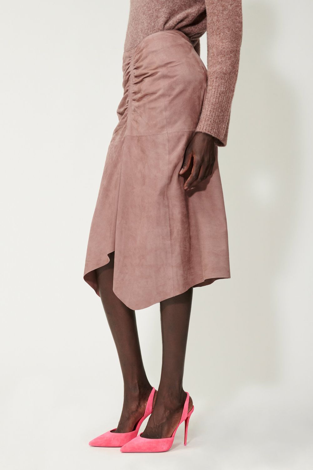 חצאית זמש א סימטרית עם כיווציםהרכב: 100% עור; בטנה: 100% פוליאסטרהדוגמנית בגובה 1.78 ולובשת מידה 36 אירופאית