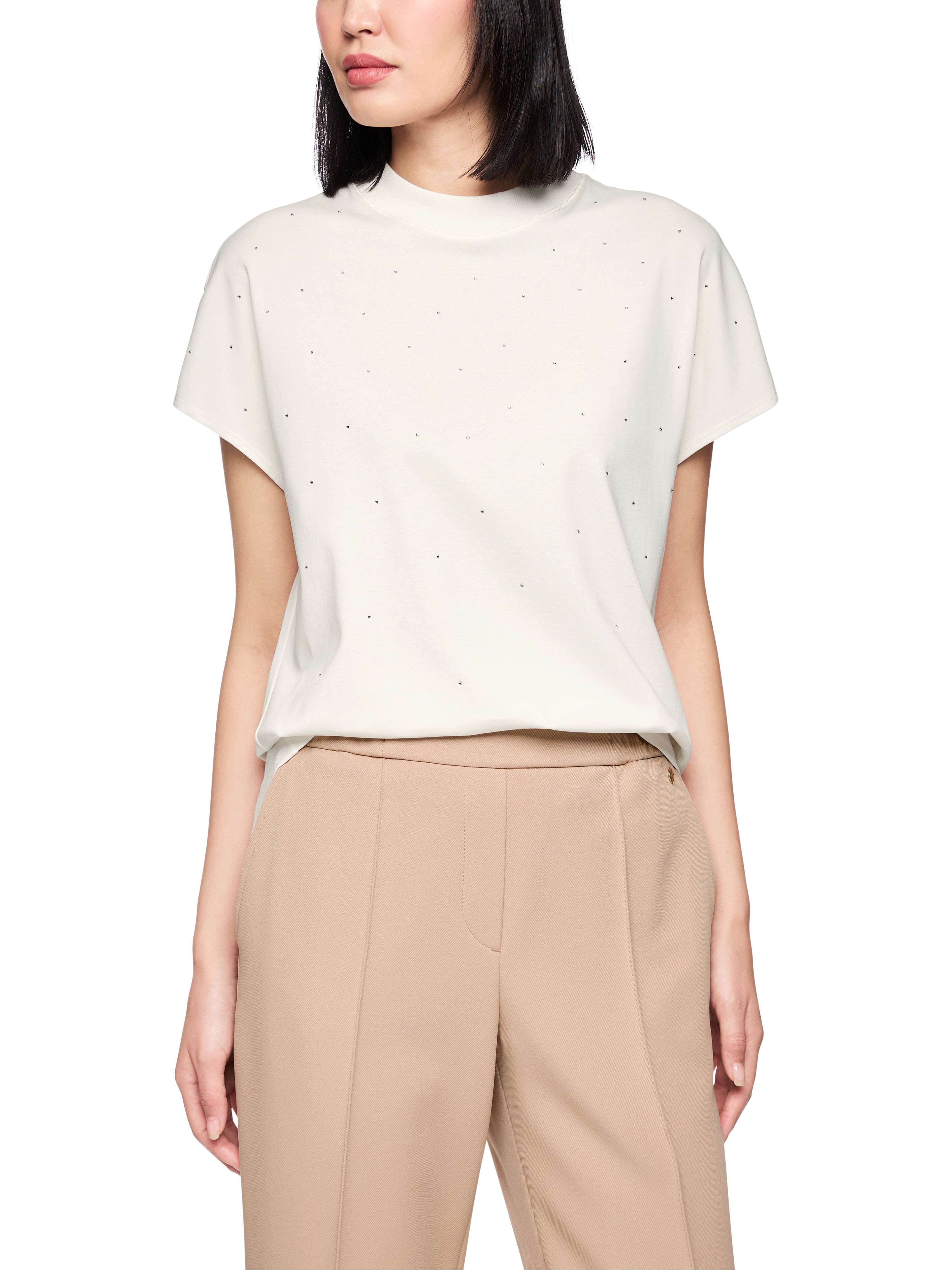 חולצת טי בעיטור אבנים מיניאטוריות בחזית וצווארון עגולהרכב: 95% כותנה, 5% אלסטןהדוגמנית בגובה 1.79 ולובשת מידה 3 של מארק קיין