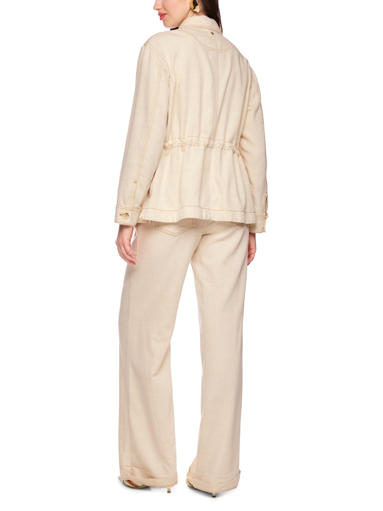 ז'קט בעיצוב קז'ואל אלגנטי, עשוי בד מתערובת כותנה ויסקוזה אלסטית ורכה, בשילוב חוט לורקס המעניק לו ברק עדין. הז'קט בגזרה ישרה ונינוחה, עם שרוך פנימי במותניים, המאפשר התאמה אישית, צווארון קלאסי, שני כיסי צד, וכיס חזה.תפרים מודגשים בצבע זהב, וסגירה באמצעות שורת כפתורים דקורטיביים משלימים את העיצוב.הרכב: 62% כותנה, 32% ויסקוזה, 4% פוליאסטר, 2% פוליאמידהדוגמנית בגובה 1.79 ולובשת מידה 3 של מארק קיין