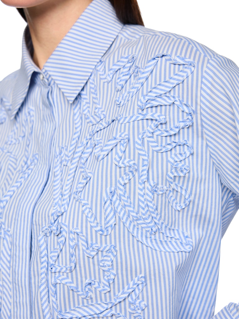 חולצת פסים מכופתרת, בגזרה נשית ונינוחה, מבד רך ונעים. דוגמת פסים בצבעי תכלת ולבן, צווארון קלאסי, שרוולים ארוכים בסיומת חפתים רחבים מכותפרים, וסגירת כפתורים נסתרת. תוספת דיטייל של עיטור בדוגמה פרחונית מעניקה לחולצה טוויסט מודרני וייחודי.הרכב: 65% כותנה, 32% פוליאסטר, 3% אלסטןהדוגמנית בגובה 1.79 ולובשת מידה 3 של מארק קיין