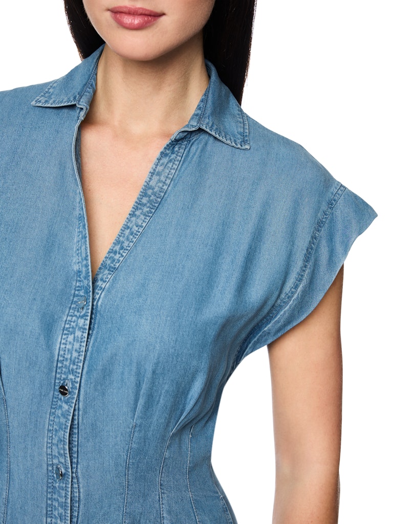 שמלת ג'ינס בעיצוב קז'ואל-אלגנטי, באורך מתחת לברך, עשויה בד קליל, רך וזורם.צווארון קלאסי עם מפתח צוואר וי, שרוולים קצרים ורחבים, קפלים עם תפרים מודגשים בקו המותן, וחצאית מתרחבת יוצרים צללית נשית. סגירת כפתורים לאורך השמלה, ושני כיסי צד.הרכב: 100% ליוסל (Tencel)הדוגמנית בגובה 1.79 ולובשת מידה 3 של מארק קיין