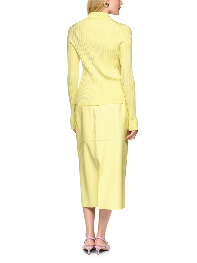 חצאית מידי עם מותן גבוהה באורך מתחת לברך, בגזרת עיפרון מתרחבת מעט לכיוון המכפלת, עשויה בד דמוי עור, רך ואלסטי. פאנלים ותפרים מודגשים, שסעים בחלק הקדמי והאחורי, בטנה פנימית דקה המעניקה נוחות, וסגירה באמצעות רוכסן אחורי דק.הרכב: 51% פוליאסטר, 49% אלסטומוליאסטרהדוגמנית בגובה 1.79 ולובשת מידה 3 של מארק קיין