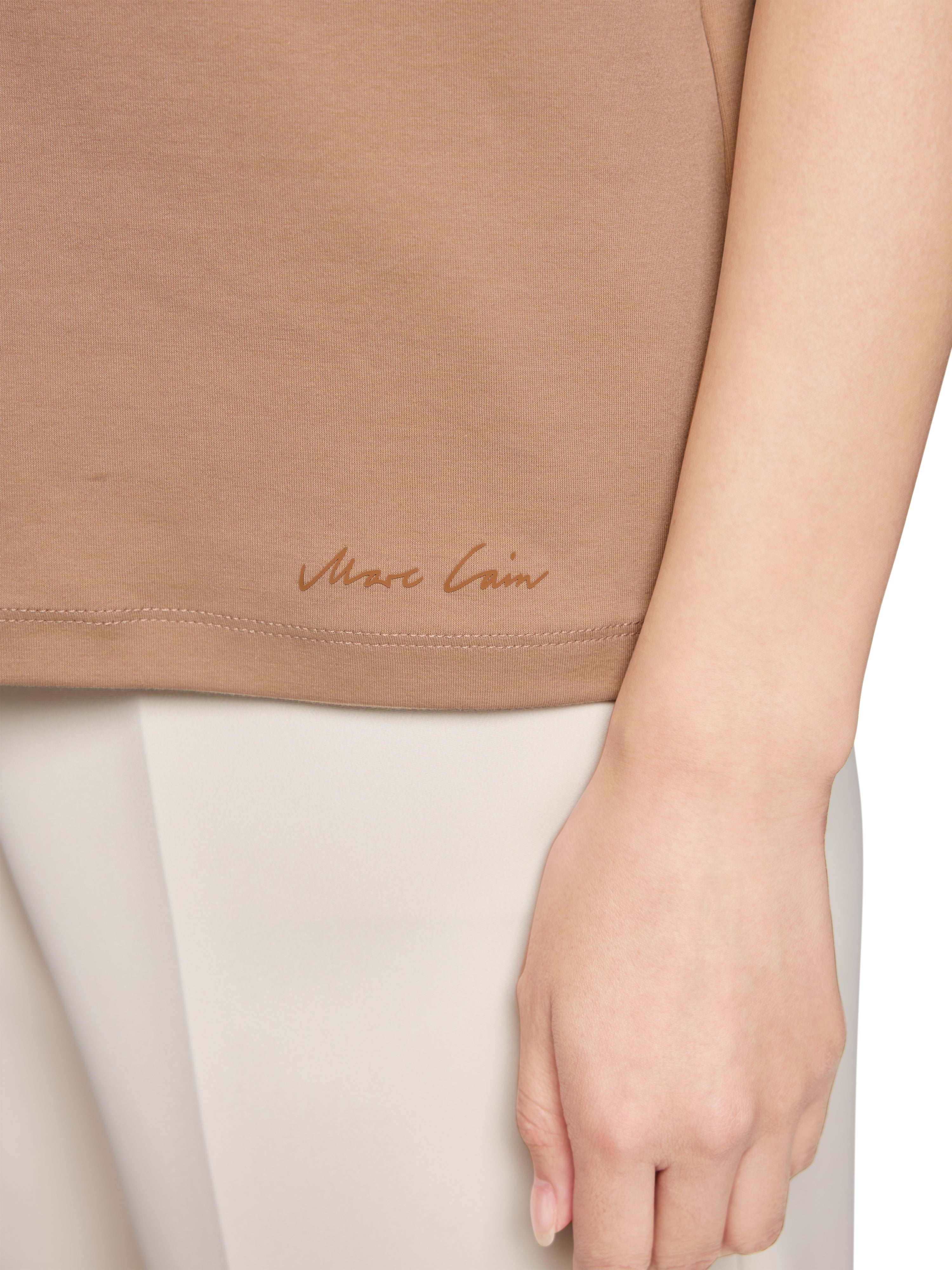 חולצת טי חצי שרוול בגזרה צמודה עם צווארון עגולהרכב: 92% כותנה, 8% אלסטןהדוגמנית בגובה 1.79 ולובשת מידה 3 של מארק קיין