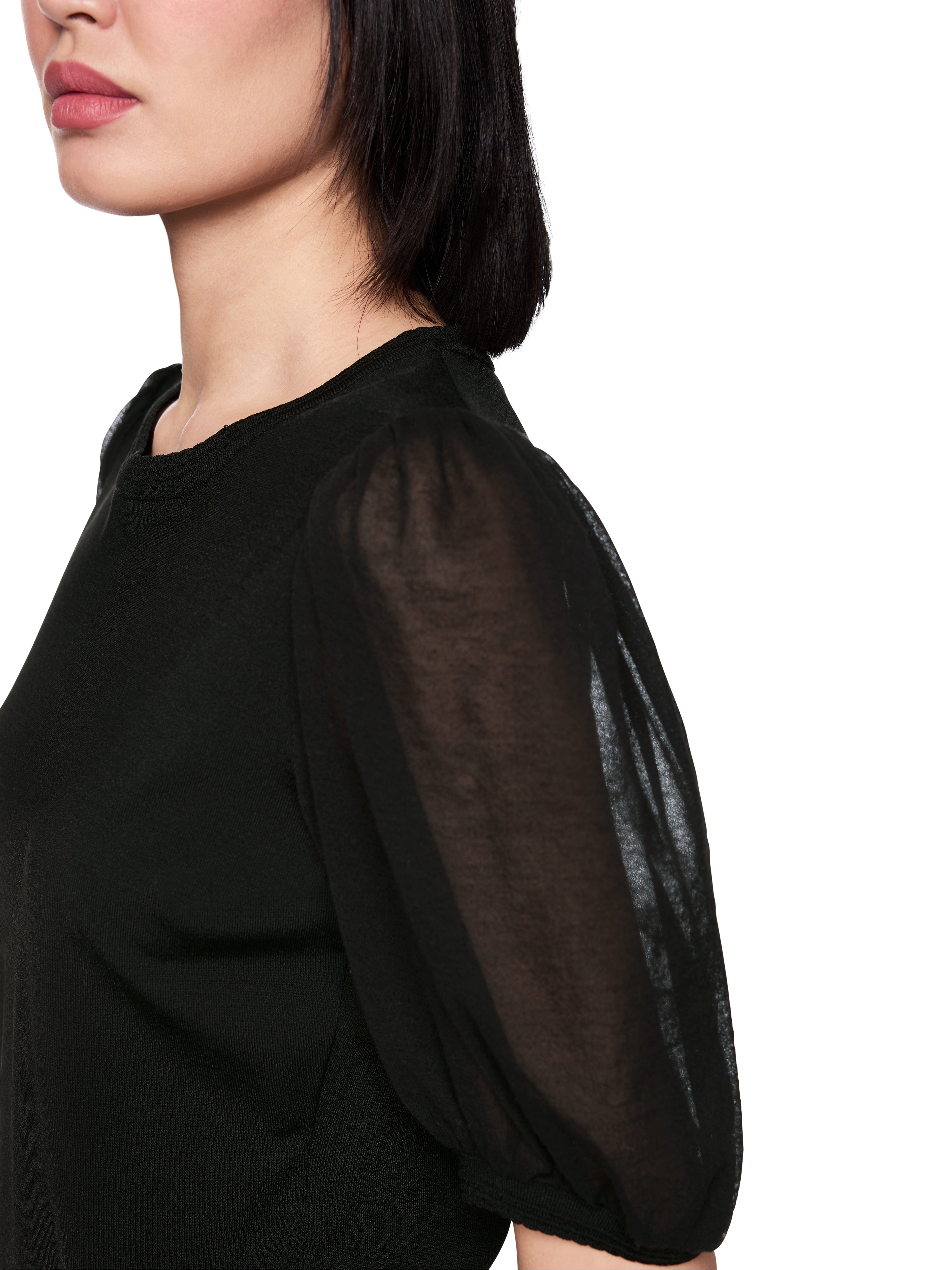 סריג דק בגזרה צמודה עם שרוולים העשויים מקרפ כותנה שקוף למחצה וצווארון עגולהרכב: 88% ויסקוזה, 12% פוליאסטרהדוגמנית בגובה 1.79 ולובשת מידה 3 של מארק קיין