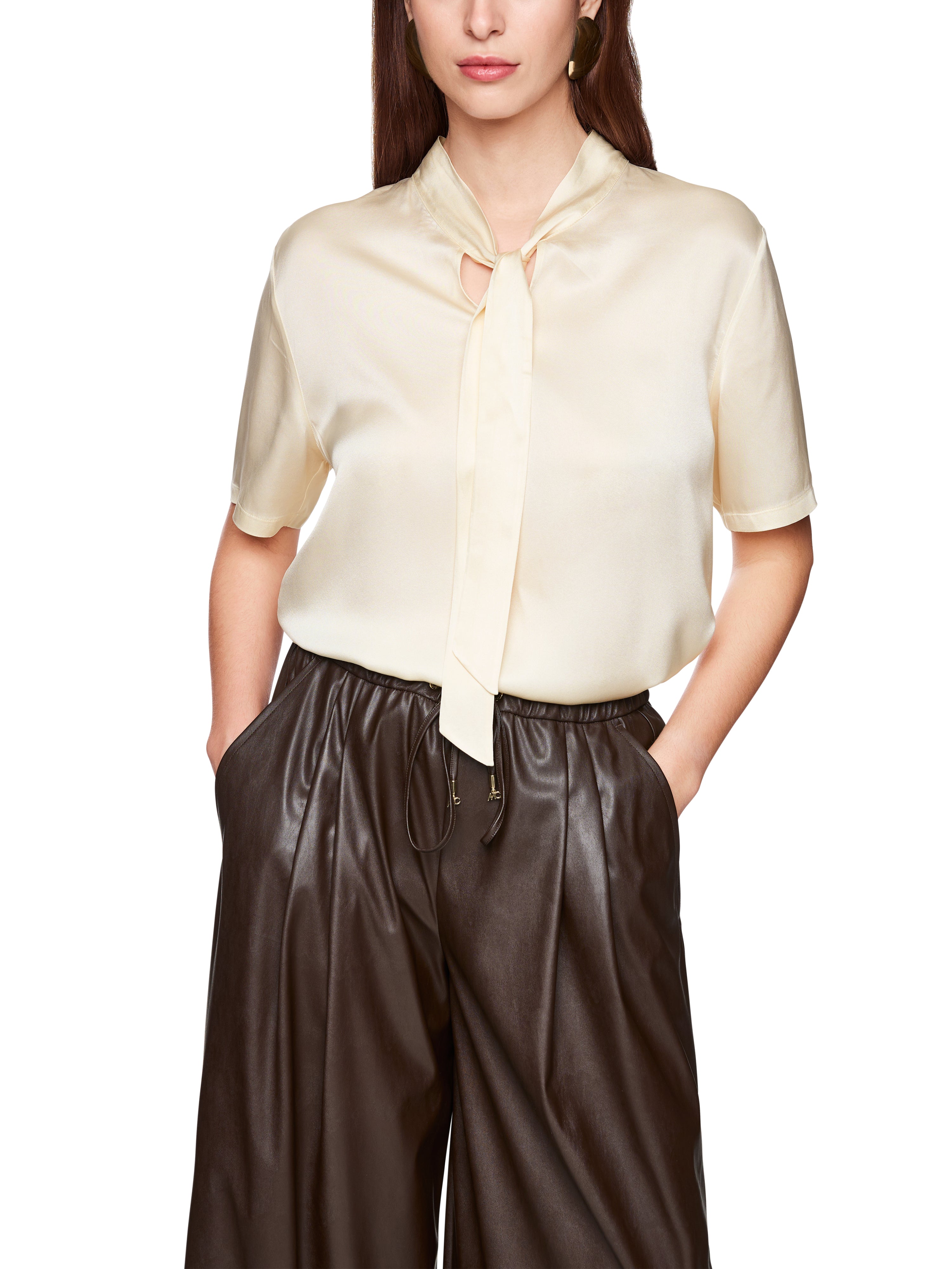 חולצת בלוזון עם שרוולים קצרים וצעיף קשירההרכב: 94% משי, 6% אלסטןהדוגמנית בגובה 1.79 ולובשת מידה 3 של מארק קיין