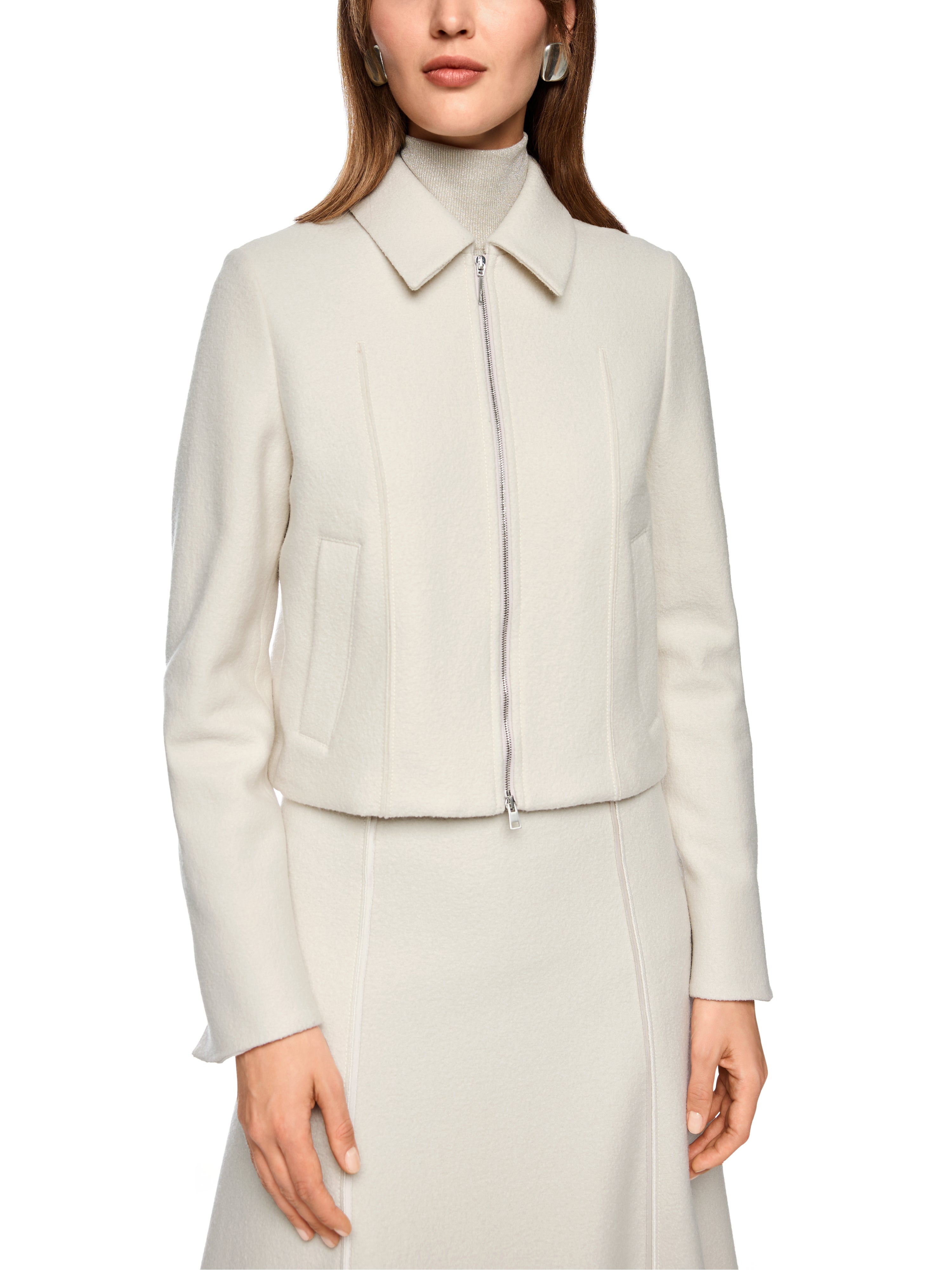 ג'קט צמר בגזרה ישרה ובצבע בז', סרוג בגימור איכותי, עם סגירת רוכסן, כיסי צד נסתרים, קצוות שרוול פתוחים וגומי בגב להדגשת המותןהרכב: 100% צמרהדוגמנית בגובה 1.79 ולובשת מידה 3 של מארק קיין