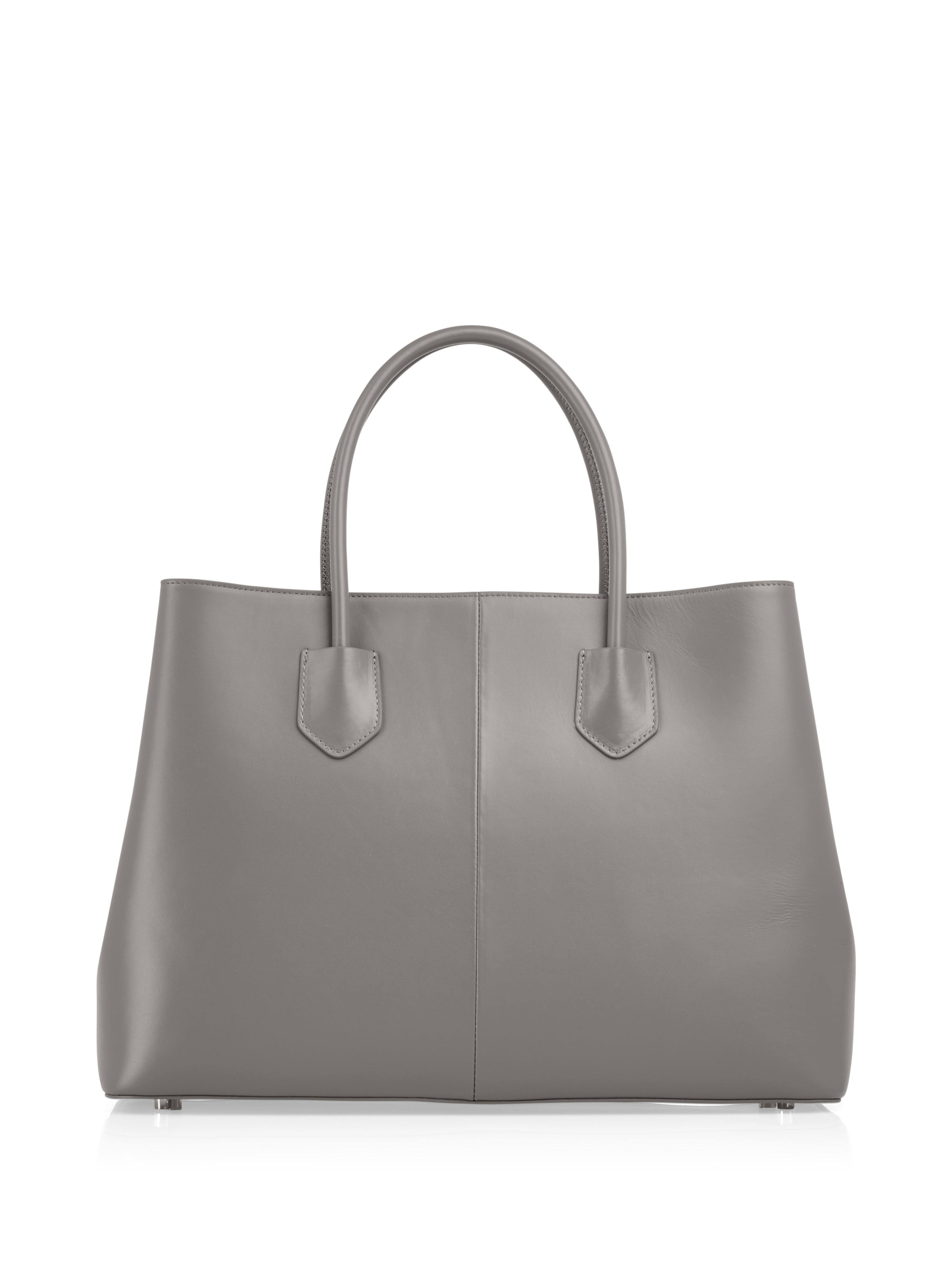 תיק נשיאה גדול מעור בצבע אפור עם שתי ידיות נשיאהבטנה מבד כותנה, עם תג לוגו דקורטיבי ורגליות תחתונות שמרימות את התחתיתהרכב: 100% עורמידות: 28*14*40 ס"מ