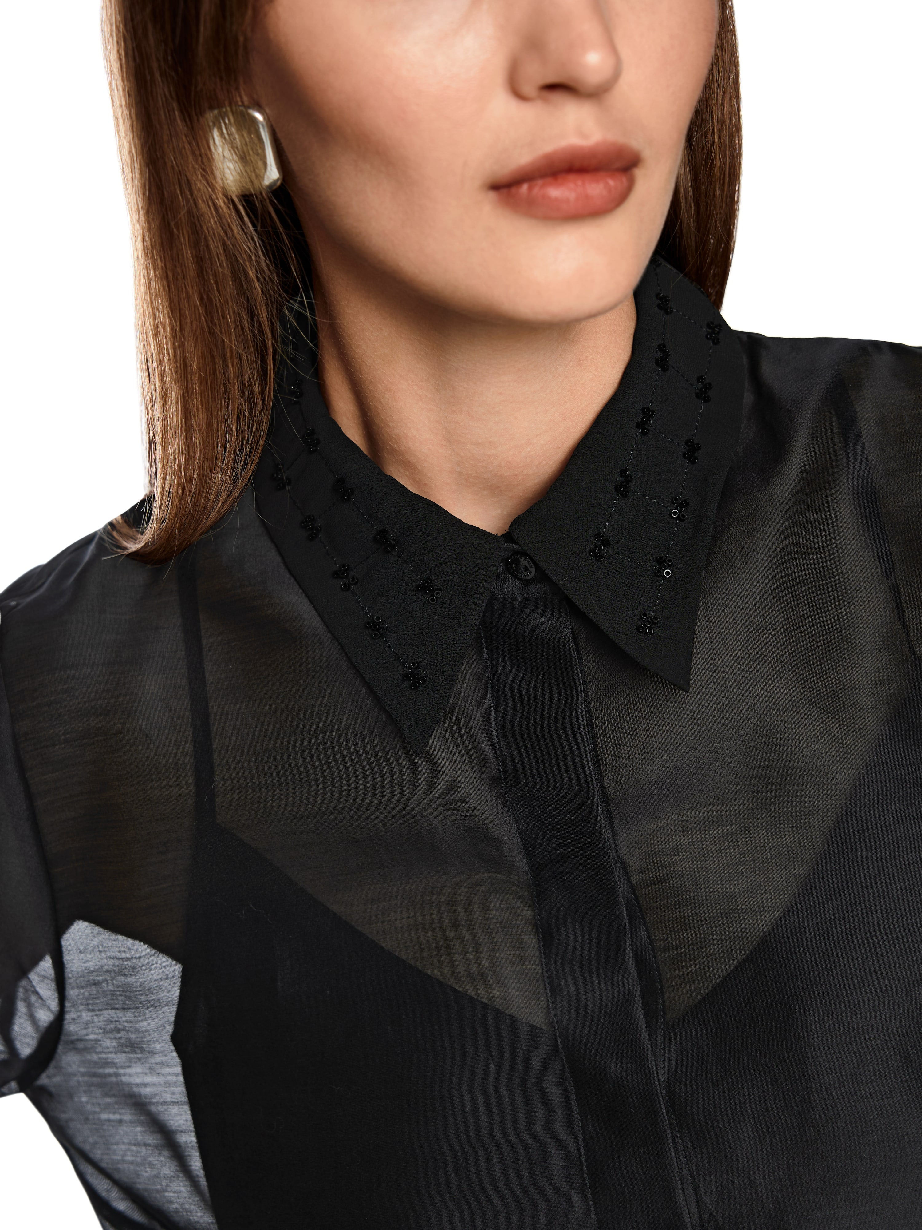 חולצת אורגנזה שקופה עם רקמה עדינה בצווארון, בגזרה רחבה עם תחתית חלקה וחלק שקוף בחלקה העליון.הרכב בד: 79% כותנה, 21% משיהדוגמנית בגובה 1.79 ולובשת מידה 3 של מארק קיין