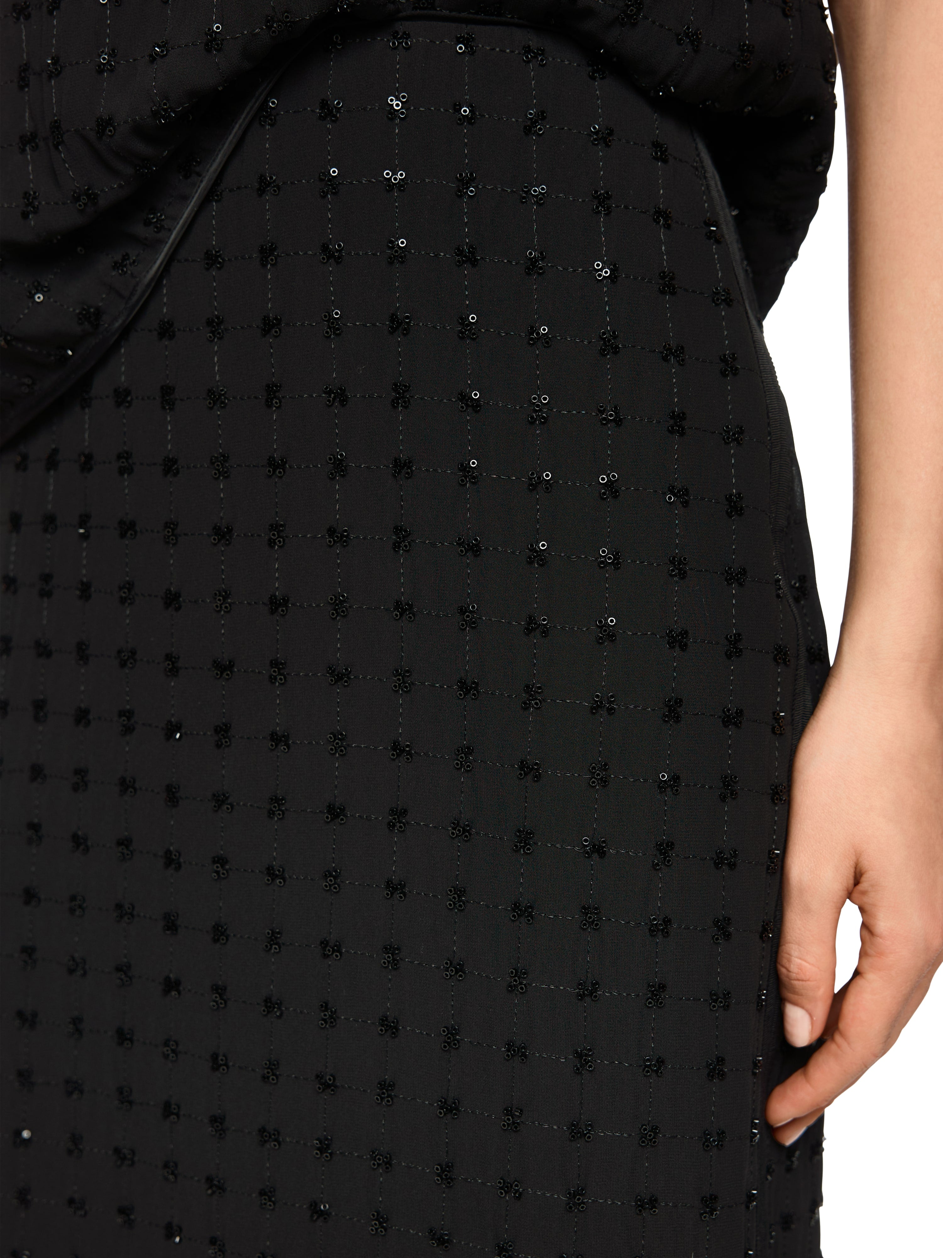 חצאית שחורה ישרה באורך מידי, רקומה כולה בפאייטים מבריקיםכוללת רוכסן נסתר ושסע אחוריהרכב בד: 100% פוליאסטרהדוגמנית בגובה 1.79 ולובשת מידה 3 של מארק קיין