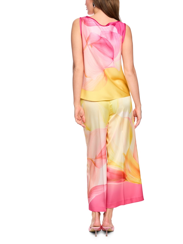טופ אלגנטי ללא שרוולים, עשוי בד סאטן רך וזורם, בהדפס דוגמת פרחי קאלה בגווני צהוב וורוד. גזרה נינוחה, עם צווארון עגול, כתפיות רחבות, וגימור פס דק בצבע ורוד פוקסיה סביב הצוואר והזרועות.הרכב: 51% פוליאסטר ממוחזר, 49% פוליאסטרהדוגמנית בגובה 1.79 ולובשת מידה 3 של מארק קיין