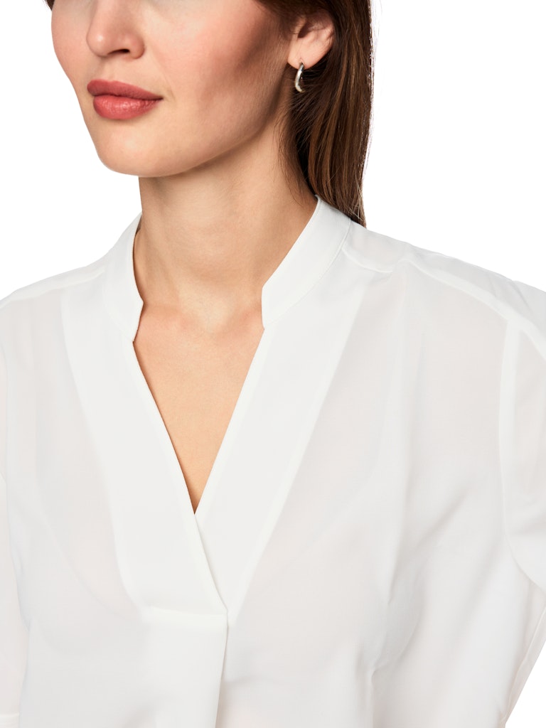 חולצה בגזרה רחבה, מבד קליל וזורם. עם שרוולים קצרים, וצווארון V עם קפל בתחתית המקנה לה צללית ייחודית. הרכב: 100% פוליאסטרהדוגמנית בגובה 1.79 ולובשת מידה 3 של מארק קיין