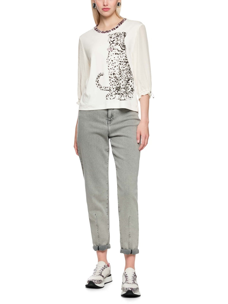 חולצה בגזרה ישרה ונינוחה, עשויה מבד כותנה גמיש ונעים, עם הדפס חזיתי של נמר, וצווארון עגול בגימור בד בדוגמה מנומרת. שרוולי החולצה באורך 3/4, מבד דק וזורם, עם חפתים אלסטיים הניתנים לכיוונון והתאמה אישית.הרכב: חולצה- 94% כותנה, 6% אלסטן, שרוולים- 59% פוליאסטר, 41% פוליאסטר ממוחזרהדוגמנית בגובה 1.79 ולובשת מידה 3 של מארק קיין