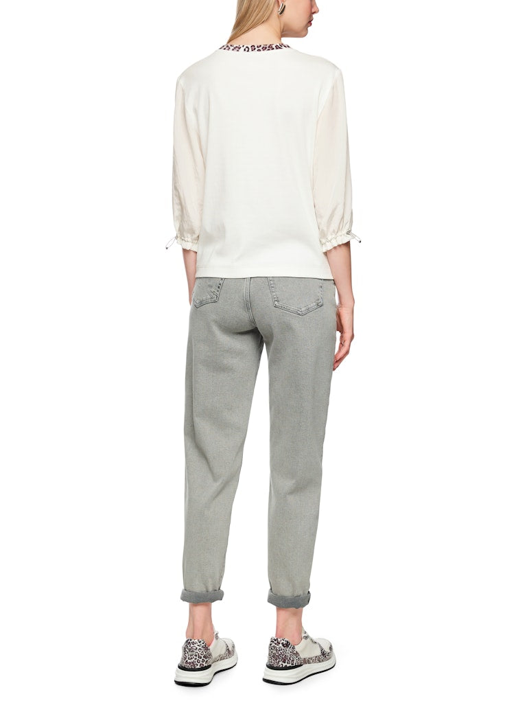 חולצה בגזרה ישרה ונינוחה, עשויה מבד כותנה גמיש ונעים, עם הדפס חזיתי של נמר, וצווארון עגול בגימור בד בדוגמה מנומרת. שרוולי החולצה באורך 3/4, מבד דק וזורם, עם חפתים אלסטיים הניתנים לכיוונון והתאמה אישית.הרכב: חולצה- 94% כותנה, 6% אלסטן, שרוולים- 59% פוליאסטר, 41% פוליאסטר ממוחזרהדוגמנית בגובה 1.79 ולובשת מידה 3 של מארק קיין