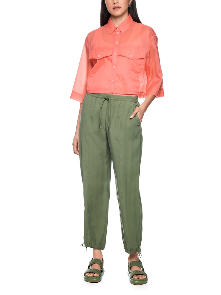 חולצה מכופתרת בגזרה רחבה ומשוחררת, ובאורך קרופ קצר, עשויה בד שקפקף וקליל במגע רך. לחולצה שרוולים רחבים באורך 3/4, שני כיסים גדולים בחזית, צווארון קלאסי, וסגירה לכל האורך באמצעות תיקתקים. מושלמת ללבישה גם כעליונית דקה.הרכב: 100% כותנה אורגניתהדוגמנית בגובה 1.79 ולובשת מידה 3 של מארק קיין