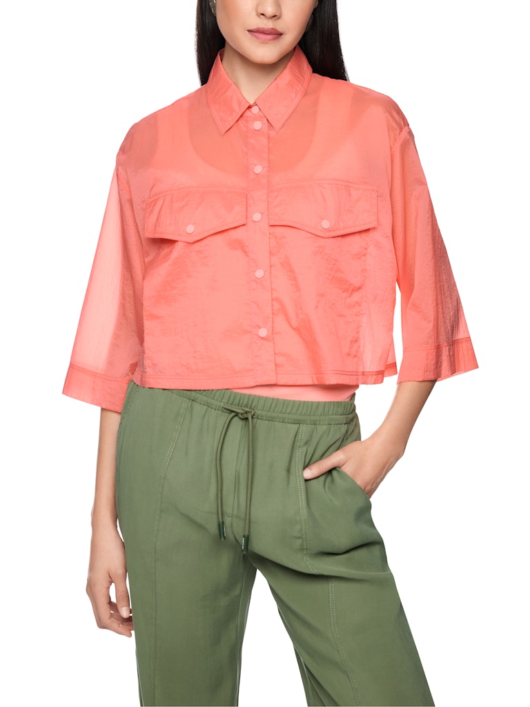 חולצה מכופתרת בגזרה רחבה ומשוחררת, ובאורך קרופ קצר, עשויה בד שקפקף וקליל במגע רך. לחולצה שרוולים רחבים באורך 3/4, שני כיסים גדולים בחזית, צווארון קלאסי, וסגירה לכל האורך באמצעות תיקתקים. מושלמת ללבישה גם כעליונית דקה.הרכב: 100% כותנה אורגניתהדוגמנית בגובה 1.79 ולובשת מידה 3 של מארק קיין