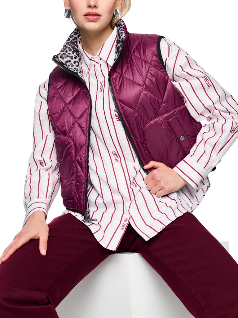 וסט קווילט דו צדדי מרופד ומחמם, צידו האחד של הוסט בגוון בורדו, וצידו השני בהדפס מנומר. עם צווארון גבוה, שני כיסים צידיים נסגרים, וסגירת רוכסן דו כיווני.הרכב: 100% פוליאסטר ממוחזרהדוגמנית בגובה 1.79 ולובשת מידה 3 של מארק קיין