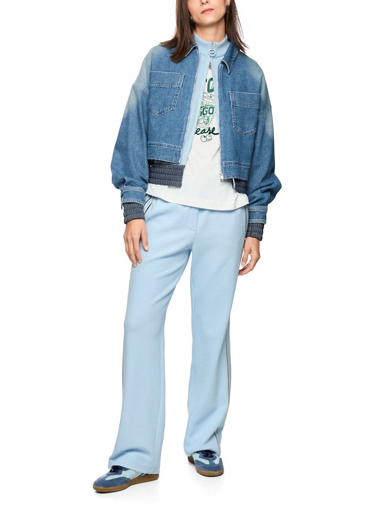 ז'קט ג'ינס באורך קצר ובגזרה נינוחה, בגוון כחול עם שטיפה ייחודית המעניקה לו מראה וינטג' אופנתי. עם צווארון קלאסי, שרוולים ארוכים בסיומת חפתים מכופתרים, כיסי פאץ' חזיתיים, וסגירה באמצעות רוכסן.הרכב: 99% כותנה, 1% אלסטןהדוגמנית בגובה 1.79 ולובשת מידה 3 של מארק קיין