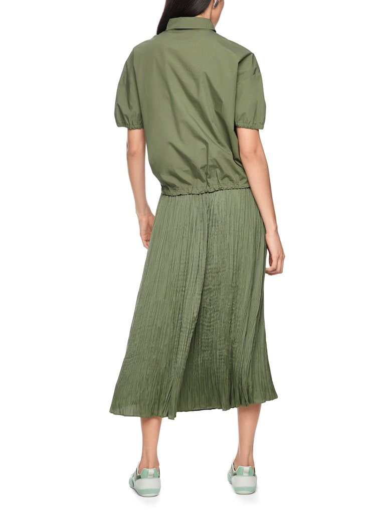 חולצה קצרה בגזרה רחבה ונינוחה, עשויה כותנה אורגנית טהורה, רכה ונעימה במיוחד. לחולצה צווארון קלאסי עם סגירת כפתורים, שרוולים קצרים ותפוחים עם סיומת כיווצים אלסטית, ומכפלת עם שרוכי קשירה בסגנון ספורטיבי, המאפשרים התאמת רוחב אישית.הרכב: 100% כותנה אורגניתהדוגמנית בגובה 1.79 ולובשת מידה 3 של מארק קיין