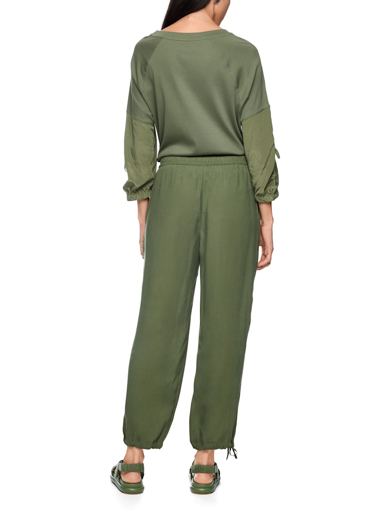 מכנסיים בעיצוב ספורטיבי, בגזרה רחבה ונינוחה, עשויים בד קליל מתערובת ויסקוזה. מותן אלסטי בגובה סטנדרטי, ומכפלת בגובה הקרסול, עם שרוכי קשירה להתאמה אישית, ושני כיסי צד.הרכב: 81% ויסקוזה, 19% פוליאסטרהדוגמנית בגובה 1.79 ולובשת מידה 3 של מארק קיין