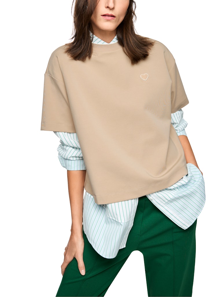 חולצת טישירט בגזרה נינוחה, עם שרוולים קצרים ורחבים, עשויה בד כותנה-מודל רך ונעים.צווארון עגול בגימור מנג'ט ריב, ודיטייל של פאץ' לב רקום בחזית.הרכב: 47% כותנה, 47% מודל, 6% אלסטןהדוגמנית בגובה 1.79 ולובשת מידה 3 של מארק קיין