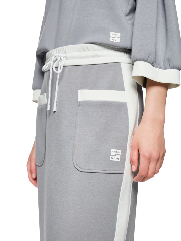 חצאית בעיצוב ספורטיבי באורך מידי, בגזרה ישרה ונינוחה, עשויה מבד רך וגולש. עם תוספת דיטייל של פסי בד בגוון אוף ווייט בצדדים, שני כיסים קדמיים, שסע אחורי, ורצועת מותן אלסטית רחבה עם חוט קשירה.הרכב: 47% פוליאמיד, 44% ויסקוזה, 9% אלסטןהדוגמנית בגובה 1.79 ולובשת מידה 3 של מארק קיין