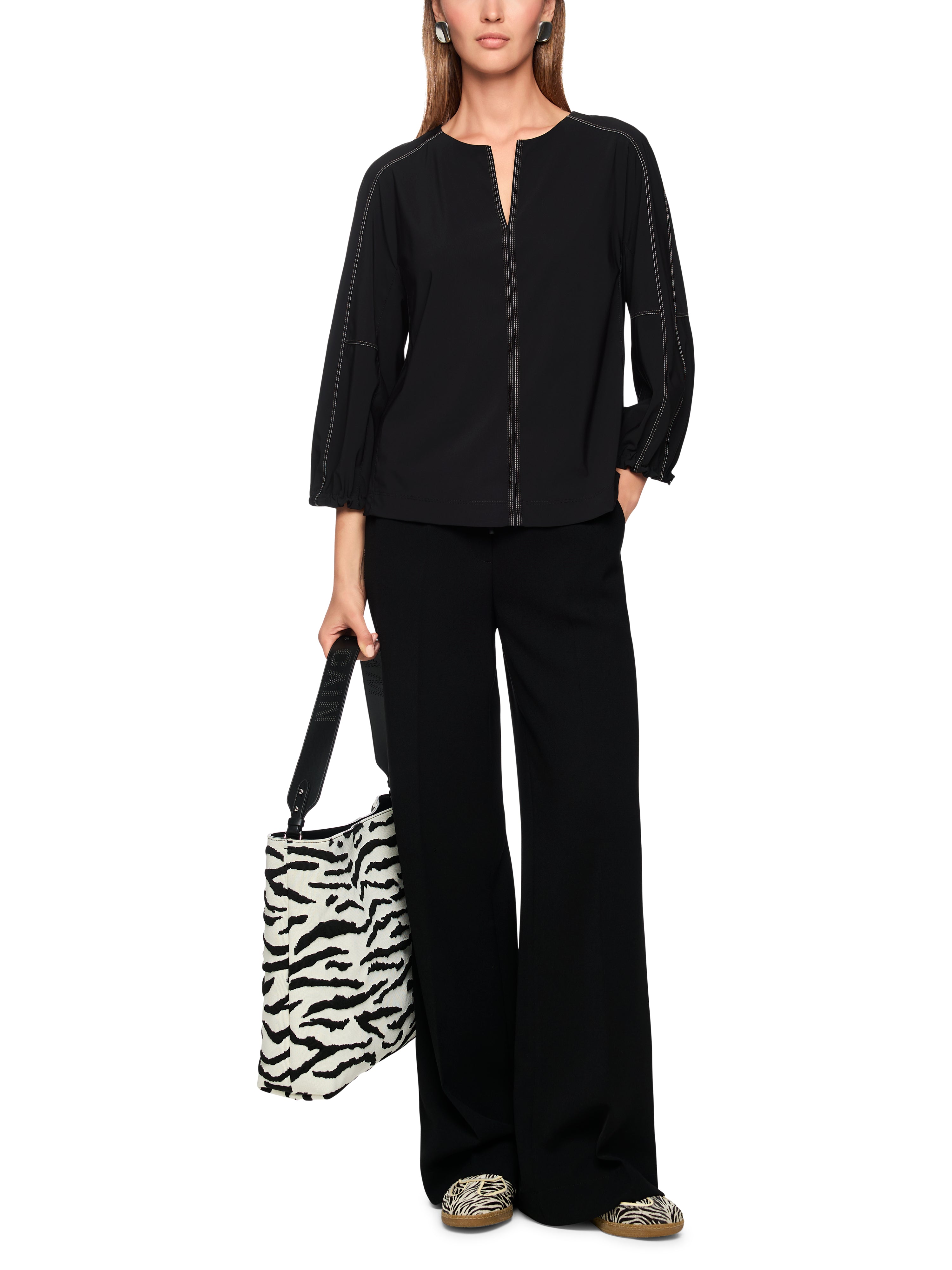 חולצה בגזרה רחבה עם שרוולים באורך 3/4 וצווארון Vהרכב: 62% פוליאמיד, 27% אלסטן, 11% פוליאמידהדוגמנית בגובה 1.79 ולובשת מידה 3 של מארק קיין