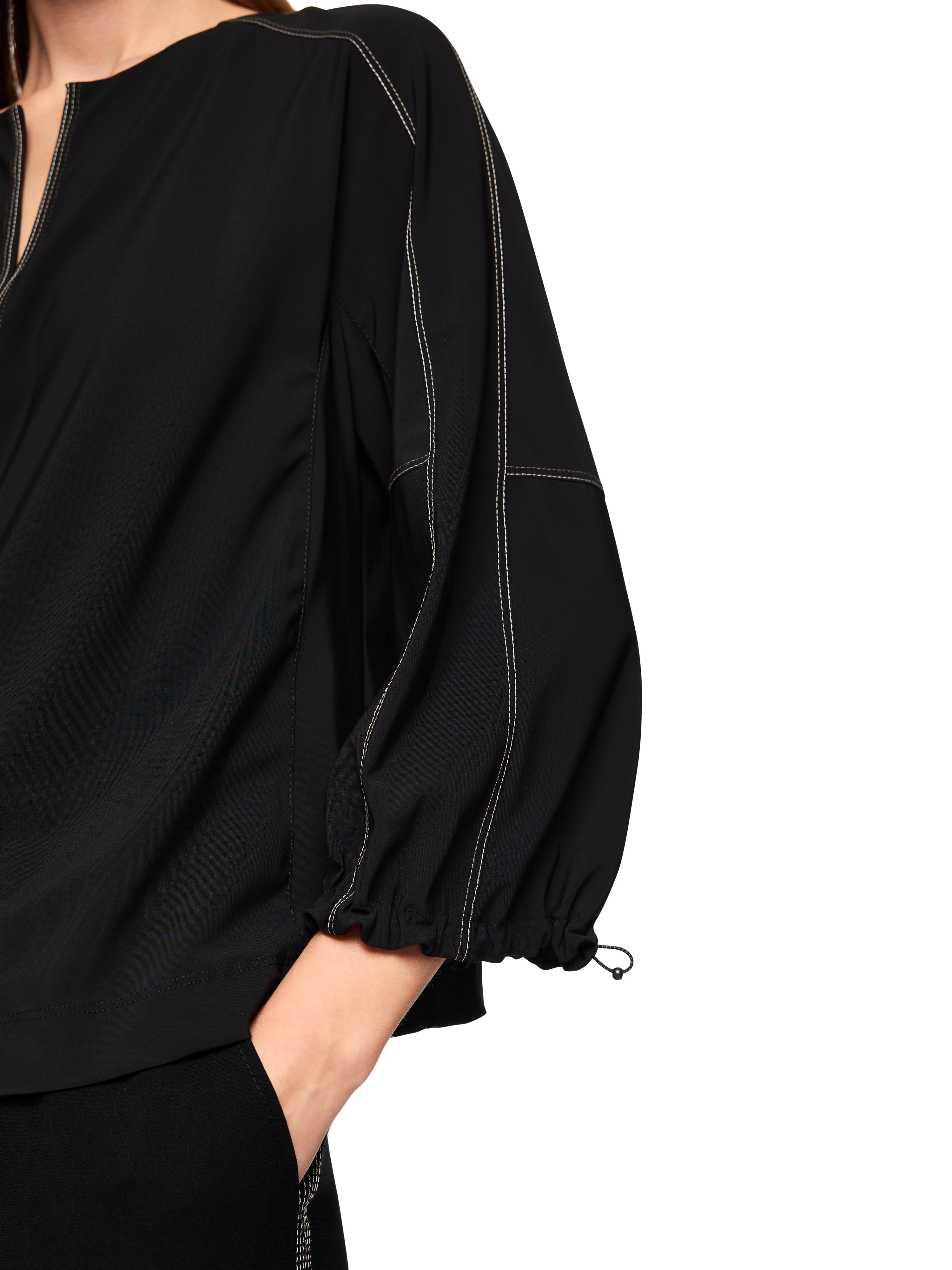 חולצה בגזרה רחבה עם שרוולים באורך 3/4 וצווארון Vהרכב: 62% פוליאמיד, 27% אלסטן, 11% פוליאמידהדוגמנית בגובה 1.79 ולובשת מידה 3 של מארק קיין