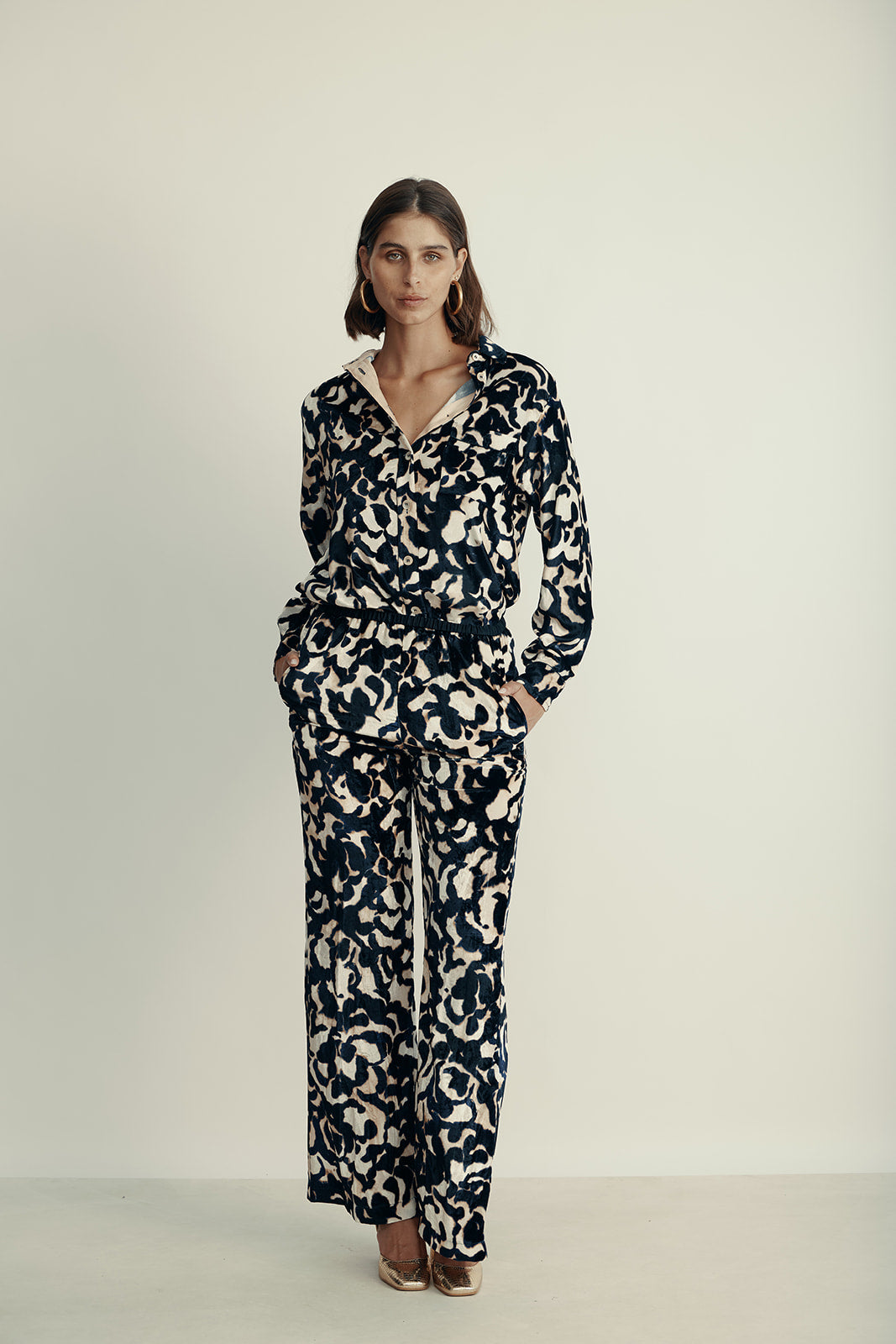 מכנסי קטיפה מתרחבים עם רצועת מותן בהדפס ורדיםהרכב: 75% ויסקוזה, 25% פוליאסטר; בד משני: 60% אצטט, 40% ויסקוזההדוגמנית בגובה 1.80 ולובשת מידה 40 איטלקית (מידה I של פורטה פורטה)