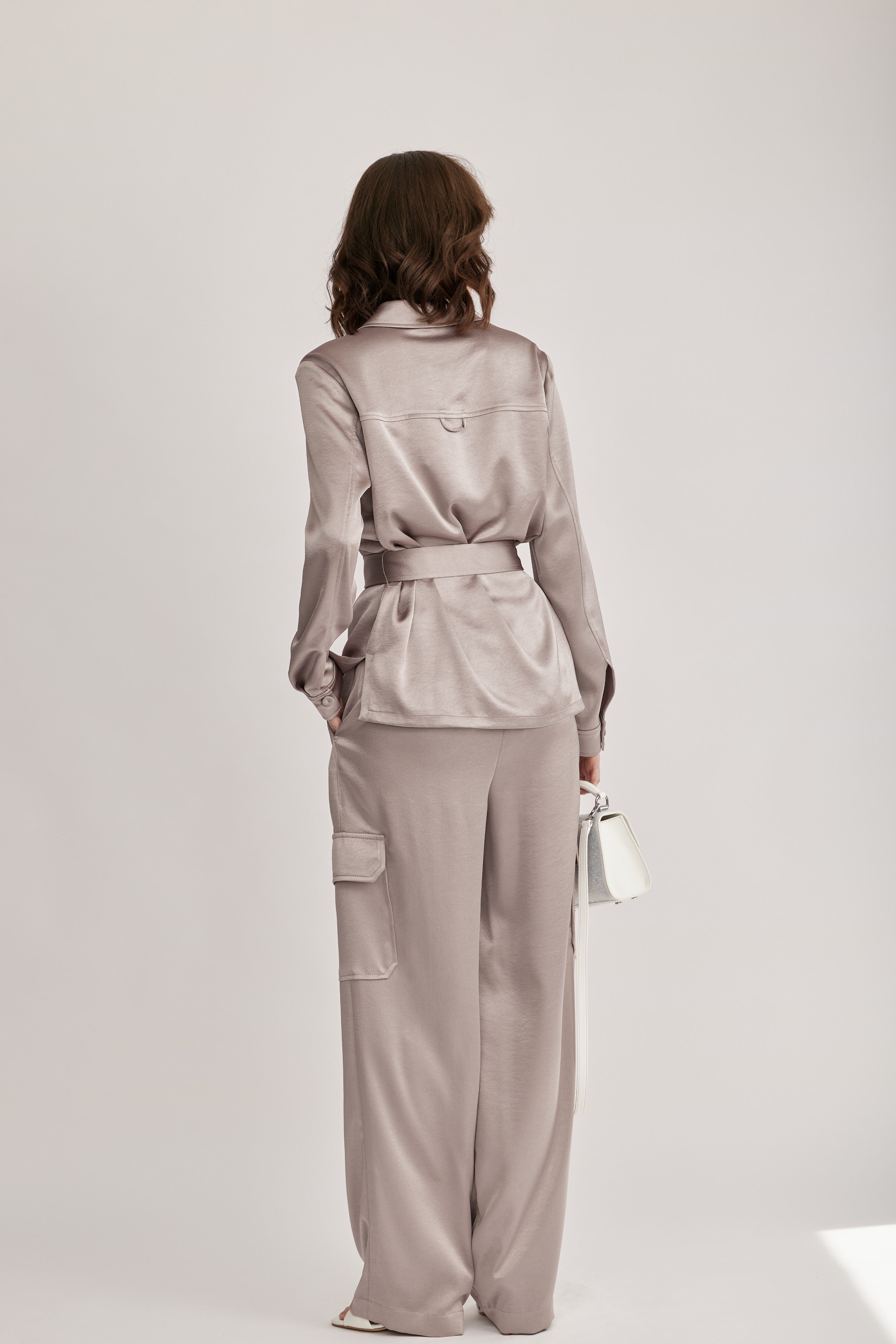 חולצה מבית המותג RIANI בעיצוב מודרני ואלגנטי, מבד סאטן רך וגולש בעל ברק מטאלי עדין, עם חגורת מותן נשלפת, להתאמה אישית ומגוון אפשרויות לבישה. גזרה ישרה, עם צווארון קלאסי, שני כיסי חזה מכופתרים, שרוולים ארוכים בגימור חפתים, וסגירת כפתורים לכל האורך.הרכב: 100% פוליאסטרהדוגמנית בגובה 1.75 ולובשת מידה 36 אירופאית