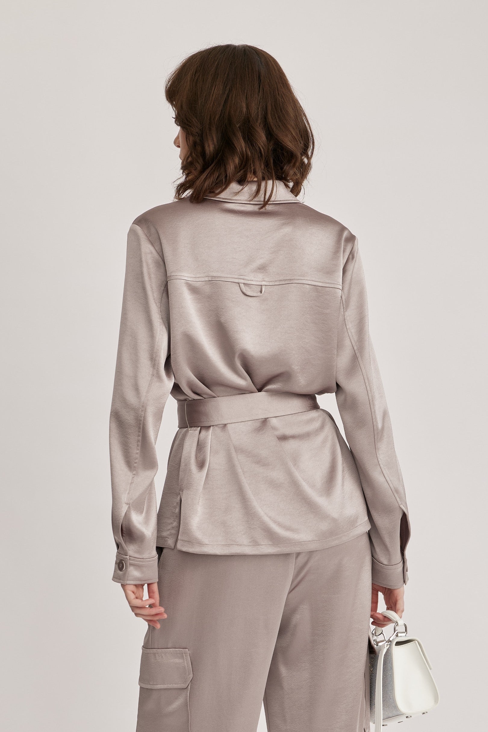 חולצה מבית המותג RIANI בעיצוב מודרני ואלגנטי, מבד סאטן רך וגולש בעל ברק מטאלי עדין, עם חגורת מותן נשלפת, להתאמה אישית ומגוון אפשרויות לבישה. גזרה ישרה, עם צווארון קלאסי, שני כיסי חזה מכופתרים, שרוולים ארוכים בגימור חפתים, וסגירת כפתורים לכל האורך.הרכב: 100% פוליאסטרהדוגמנית בגובה 1.75 ולובשת מידה 36 אירופאית