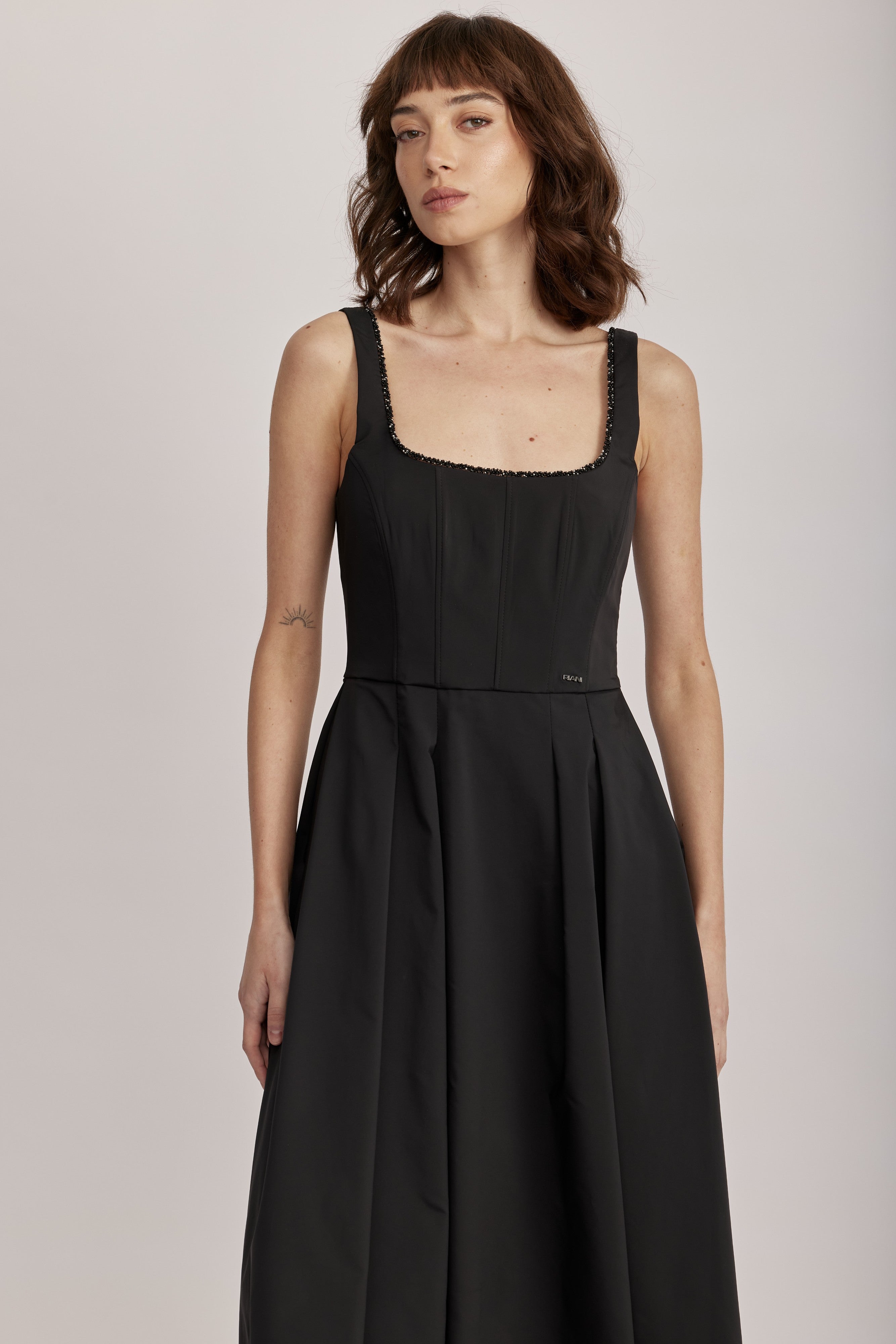 שמלה מבית המותג RIANI, בעיצוב קלאסי. גזרת A עם חצאית קפלים מתרחבת, מבד קליל וזורם. מחשוף מרובע, גב במפתח עמוק, וכתפיות גופיה רחבות ומעוטרות משלימים את העיצוב ויוצרים צללית מודרנית ונשית, וסטייל על זמני שיתאים לכל אירוע. עם כיסי צד וסגירה באמצעות רוכסן בגב.הרכב: 100% פוליאסטרהדוגמנית בגובה 1.75 ולובשת מידה 36 אירופאית