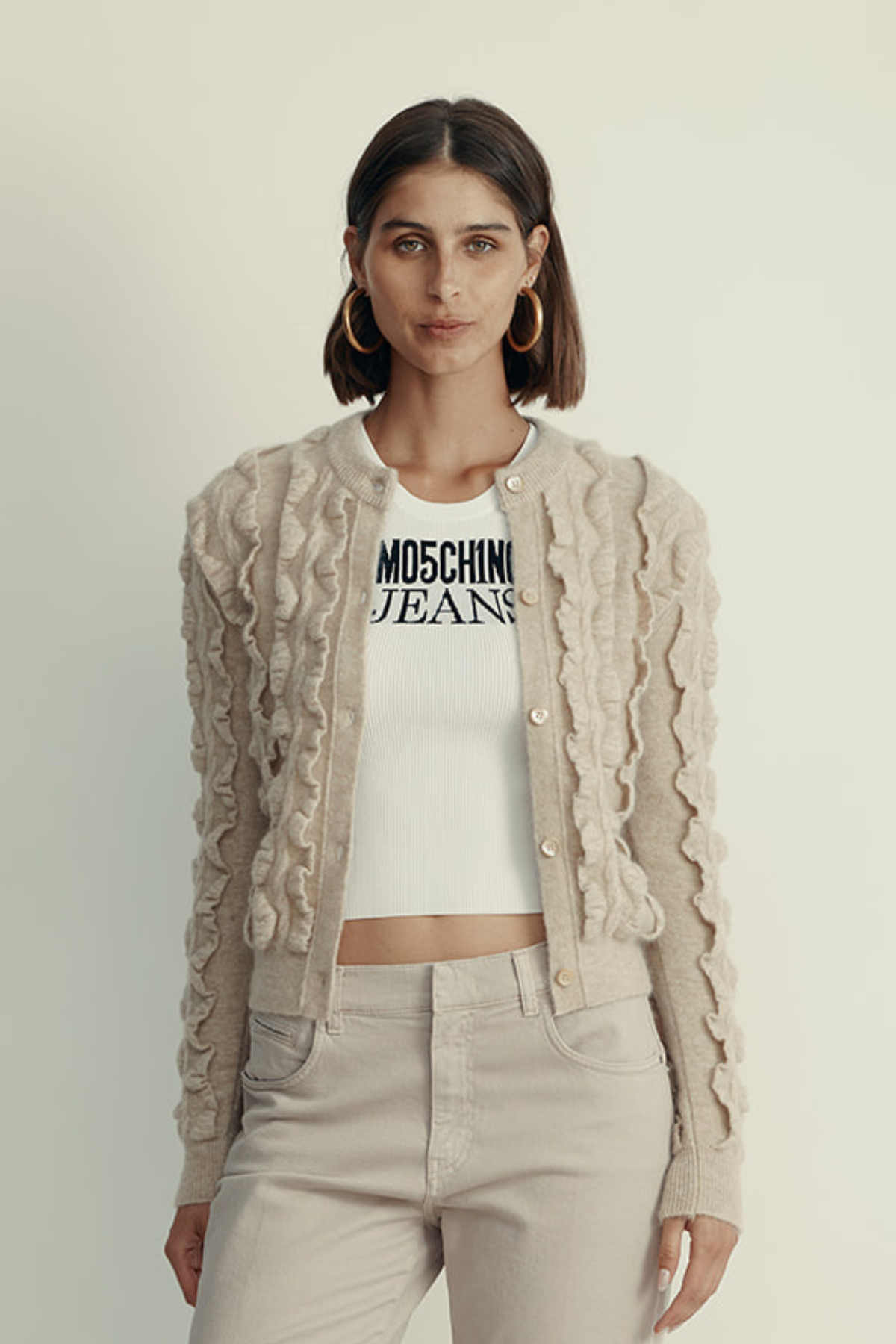 קרדיגן מקולקציית MOSCHINO Couture עם אלמנט מלמלה וסגירת כפתוריםהרכב: 30% צמר וירג'ין, 38% פוליאמיד, 31% מוהיר, 1% אלסטןהדוגמנית בגובה 1.80 ולובשת מידה 42 איטלקית