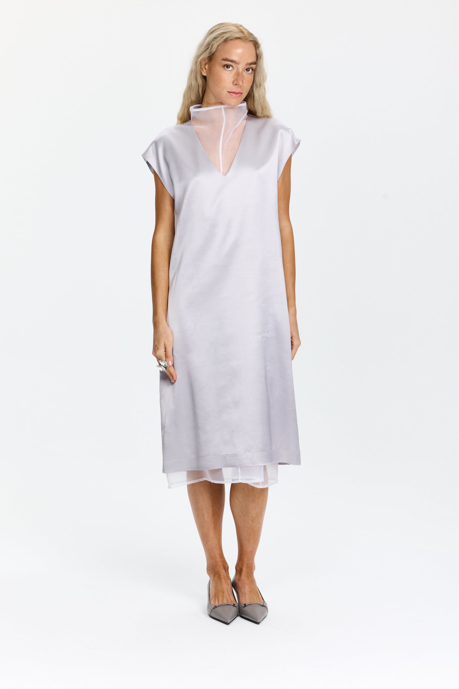 שמלה ללא שרוולים באורך מידי, מחשוף V עם צווארון עומד, סגירת רוכסן וכפתור, וכיסים אלכסוניים. כוללת שכבת בטנה פנימית הניתנת לשליפההרכב בד: 77% ויסקוזה, 23% צמר בתוליהדוגמנית בגובה 1.75 ולובשת מידה 42 של Peserico