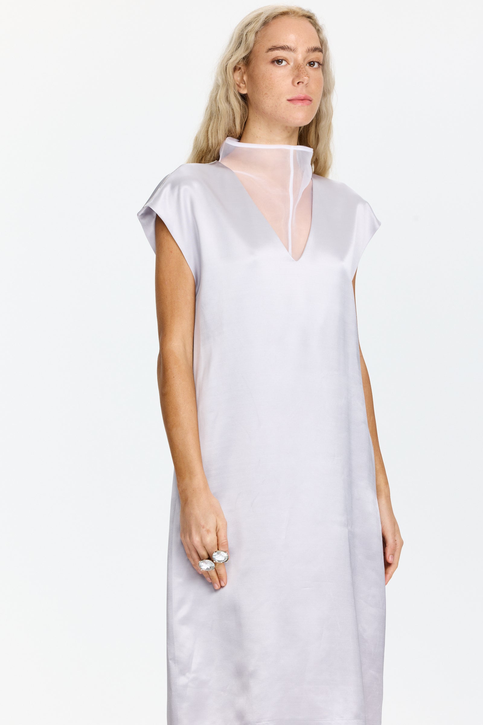 שמלה ללא שרוולים באורך מידי, מחשוף V עם צווארון עומד, סגירת רוכסן וכפתור, וכיסים אלכסוניים. כוללת שכבת בטנה פנימית הניתנת לשליפההרכב בד: 77% ויסקוזה, 23% צמר בתוליהדוגמנית בגובה 1.75 ולובשת מידה 42 של Peserico