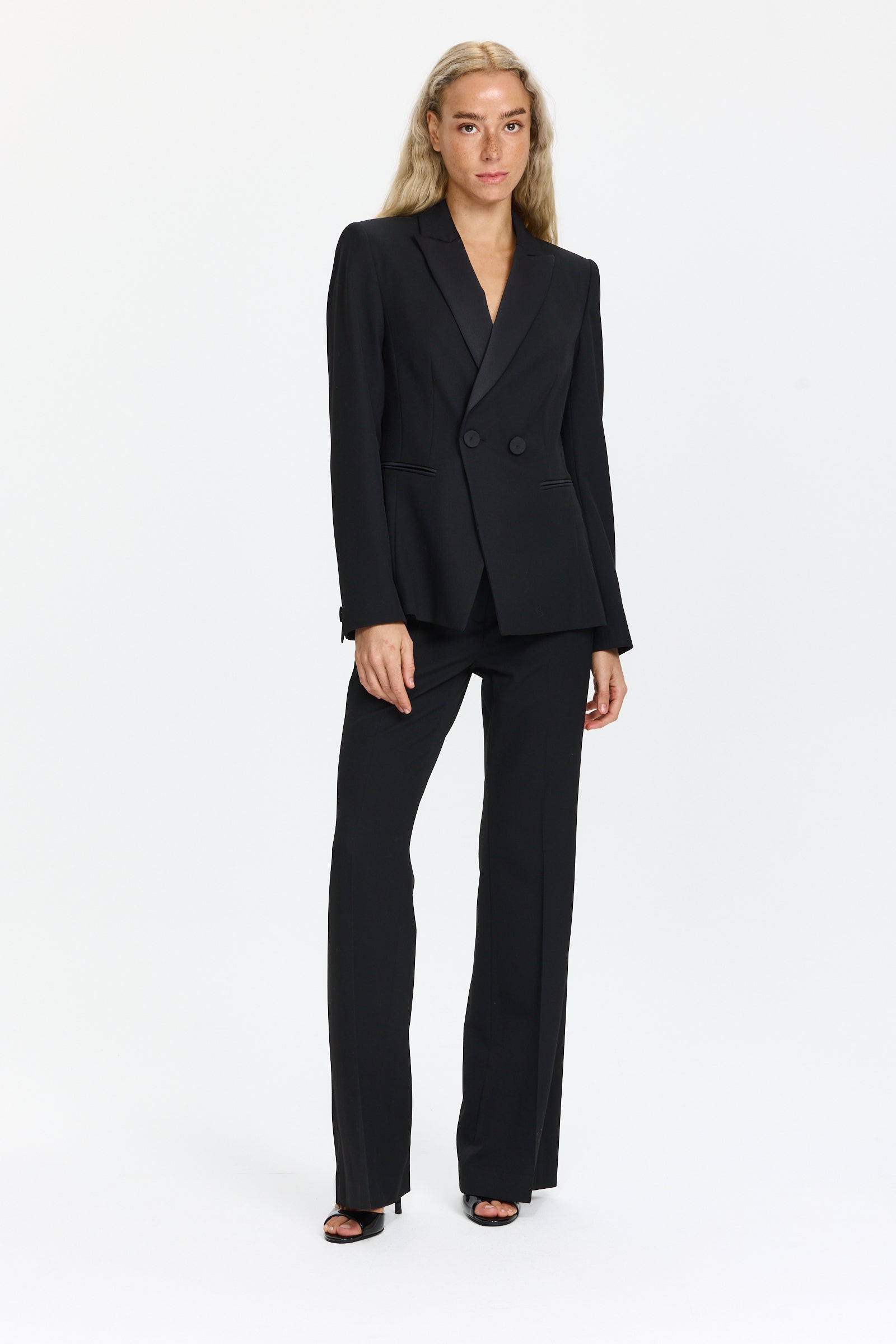 בלייזר טוקסידו בצבע שחור עם סגירה כפולה, שני כיסים וכריות כתףהרכב הבד: 67% פוליאסטר, 29% ויסקוזה, 4% אלסטןהדוגמנית בגובה 1.75 ולובשת מידה 36 של Luisa Cerano