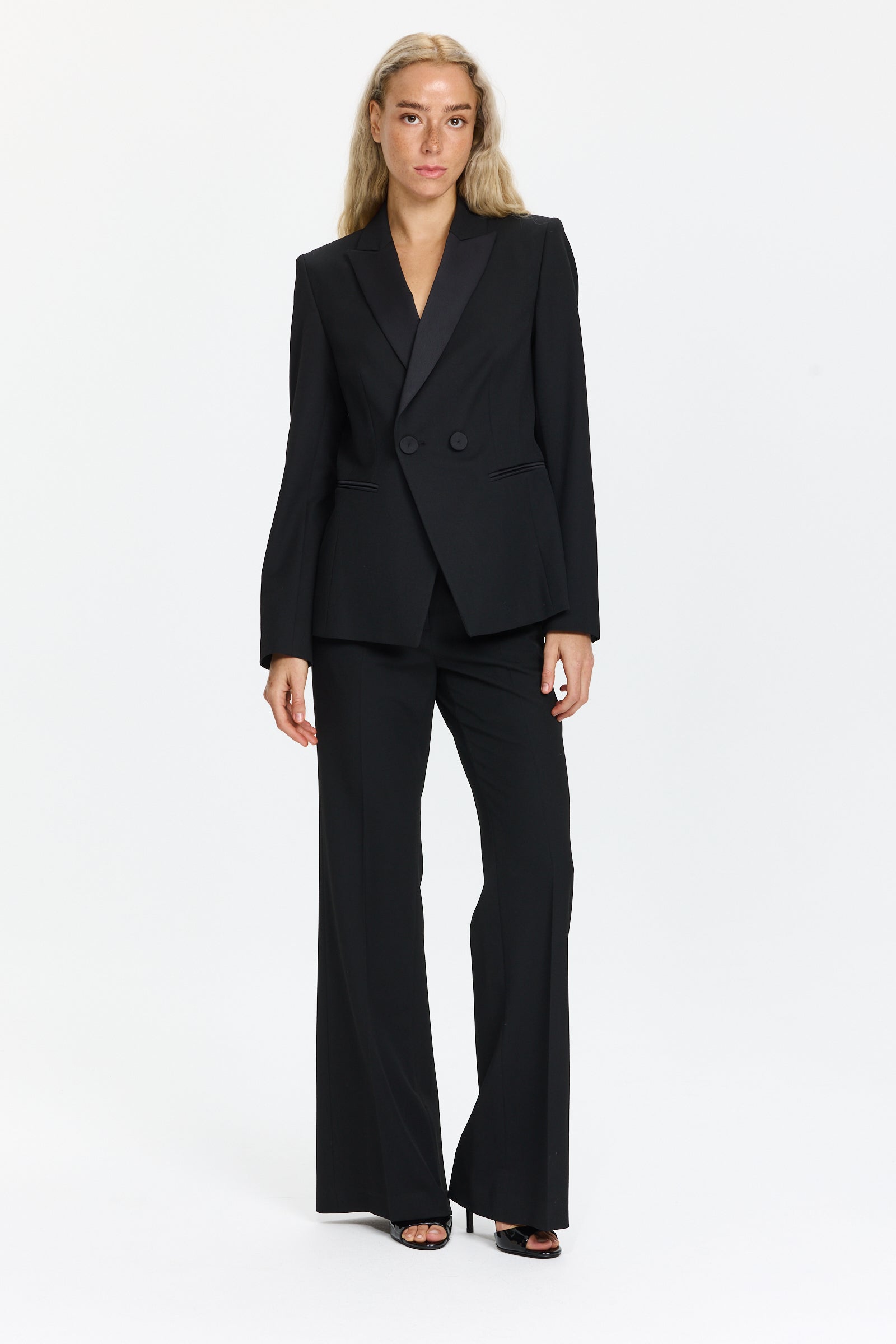 מכנסיים מחוייטים בגזרה ישרה בצבע שחור עמוק, עם כפתורים לצד הכיסיםהרכב הבד: 67% פוליאסטר, 29% ויסקוזה, 4% אלסטןהדוגמנית בגובה 1.75 ולובשת מידה 36 של Luisa Cerano