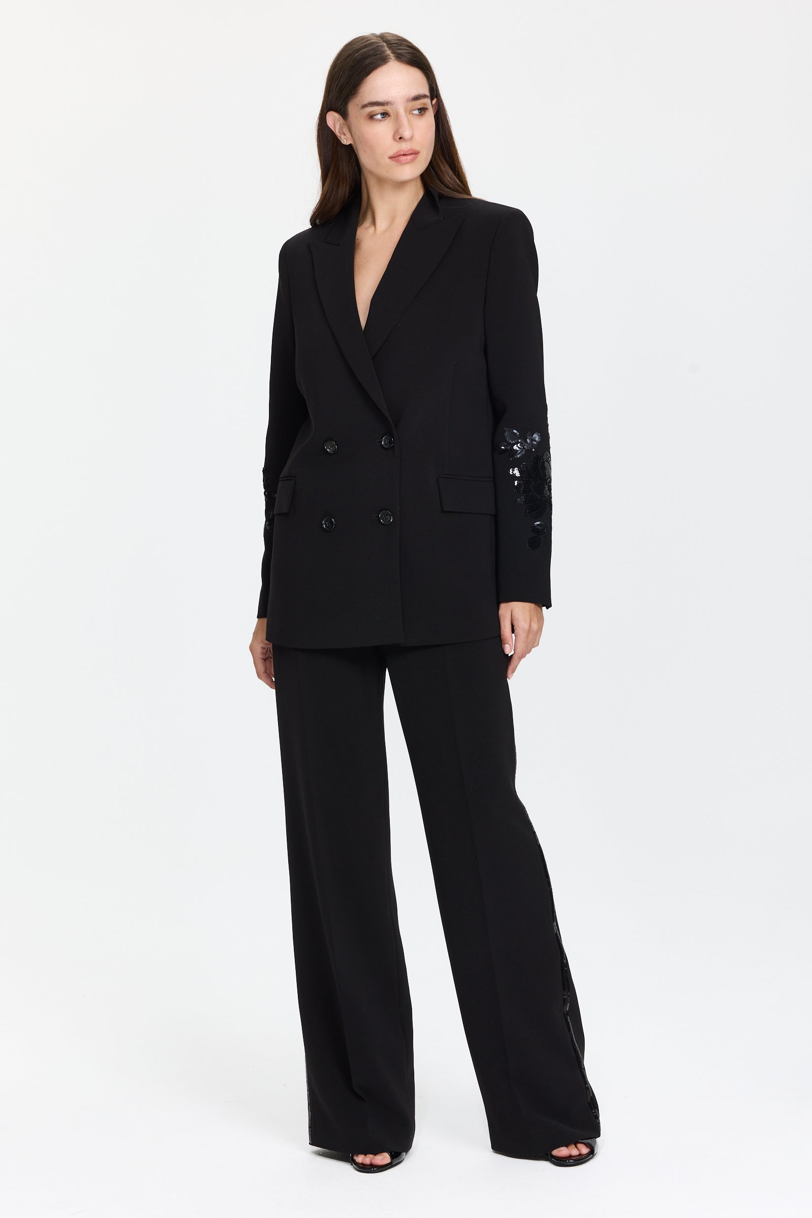 ז’קט בלייזר בצבע שחור עם פאייטים בשרווליםכולל כיסים צדדיים ומראה אלגנטיהרכב בד: 94% פוליאסטר, 6% אלסטןהדוגמנית בגובה 1.75 ולובשת מידה 42 של Ermanno Scervino