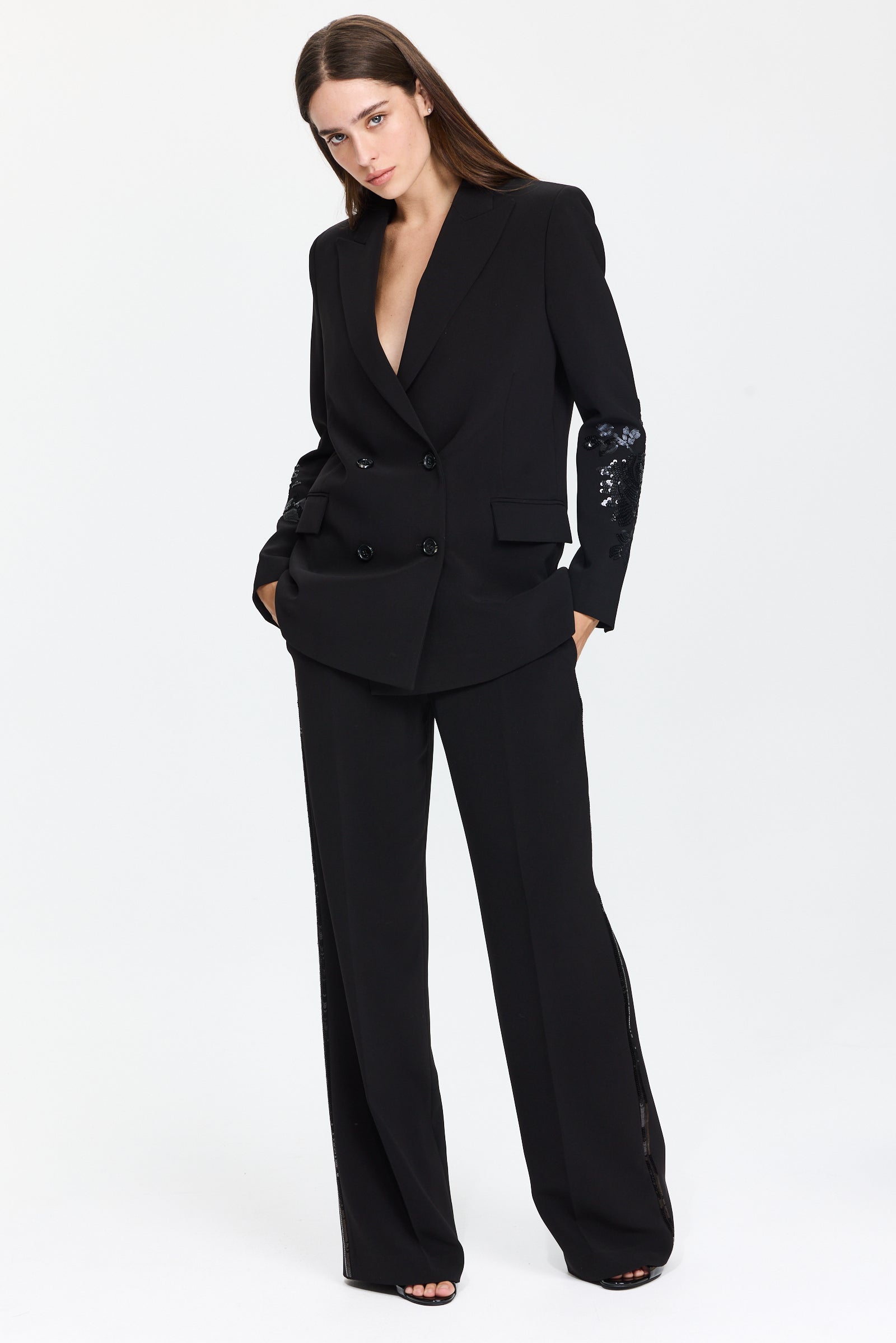 מכנסיים אלגנטיים בגזרה ישרה עם פסים רקומים בנצנצים בצדדיםהרכב בד: 94% פוליאסטר, 6% אלסטןהדוגמנית בגובה 1.75 ולובשת מידה 42 של Ermanno Scervino