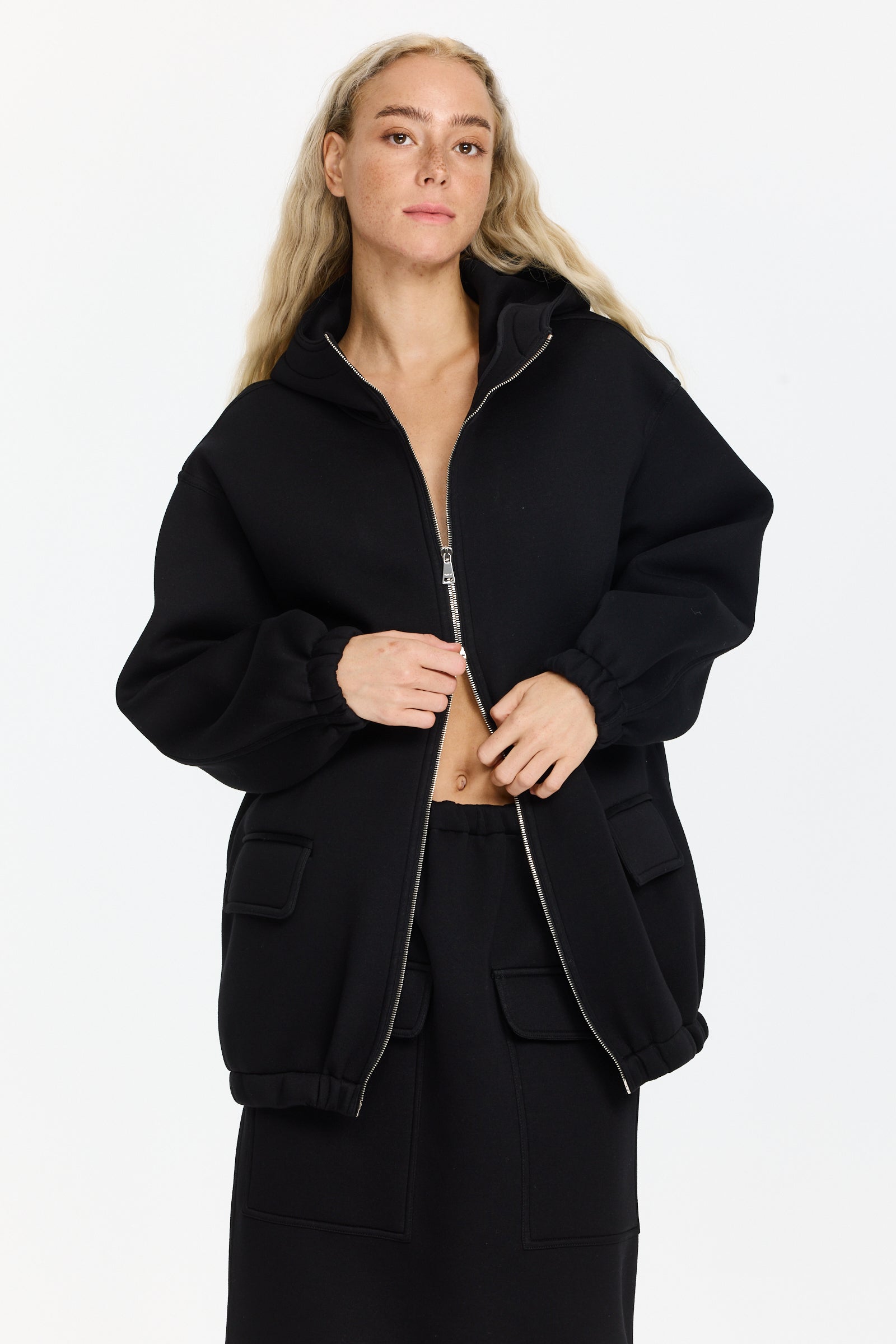 ז'קט שחור בסגנון סקובה עם קפוצ'ון, סגירה קדמית ברוכסן כפול ושני כיסים קדמיים עם סגירה בדשהרכב בד: 100% ויסקוזההדוגמנית בגובה 1.75 ולובשת מידה 38 של Plan C