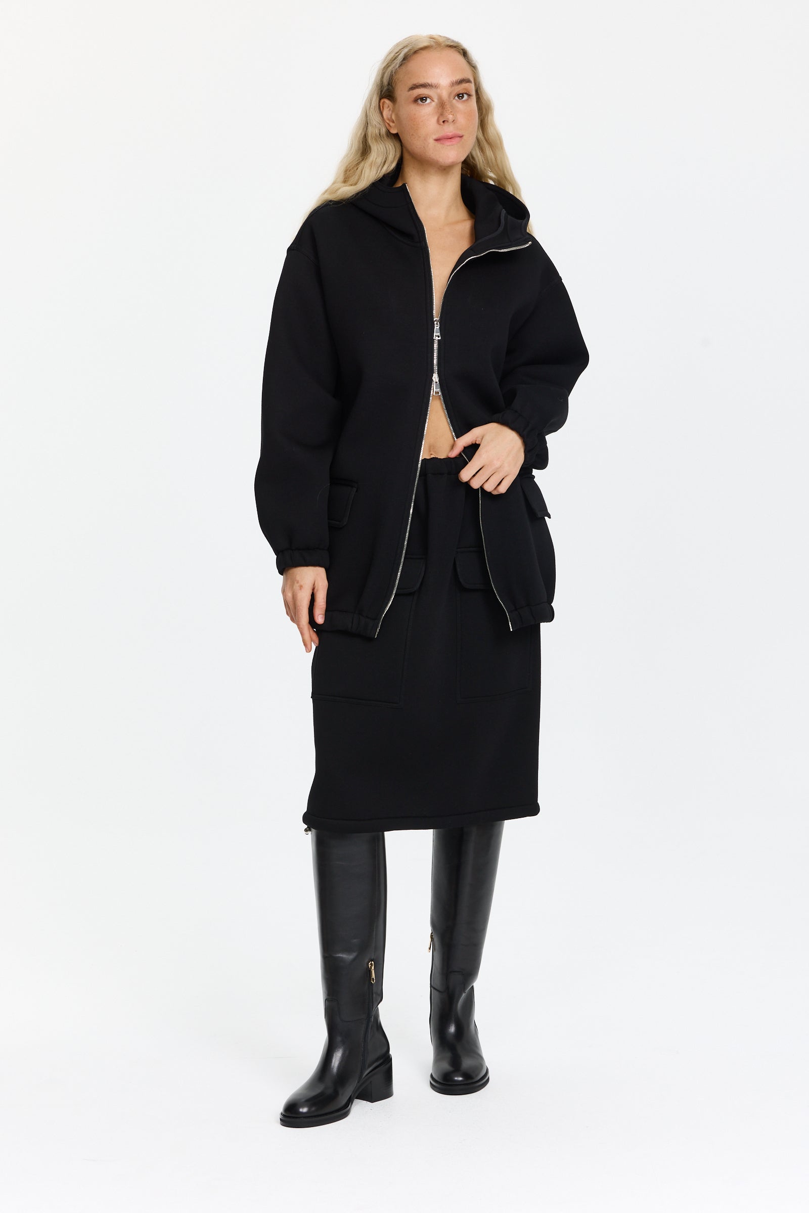 חצאית שחורה באורך מידי עם מותן אלסטית ושני כיסים קדמיים עם דשים, אפשרות לכיווץ בתחתיתהרכב בד: 100% ויסקוזההדוגמנית בגובה 1.75 ולובשת מידה 38 של Plan C