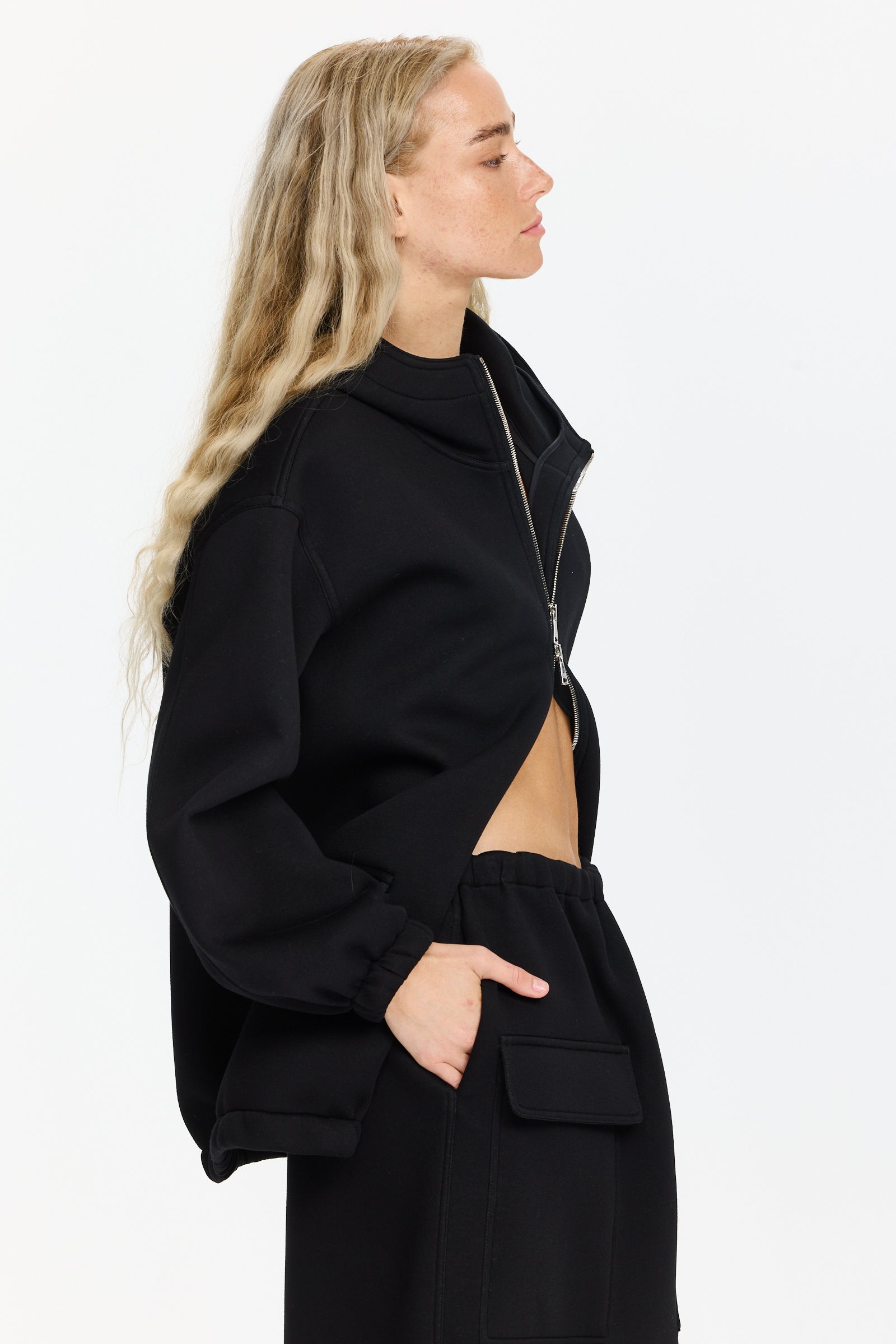 ז'קט שחור בסגנון סקובה עם קפוצ'ון, סגירה קדמית ברוכסן כפול ושני כיסים קדמיים עם סגירה בדשהרכב בד: 100% ויסקוזההדוגמנית בגובה 1.75 ולובשת מידה 38 של Plan C