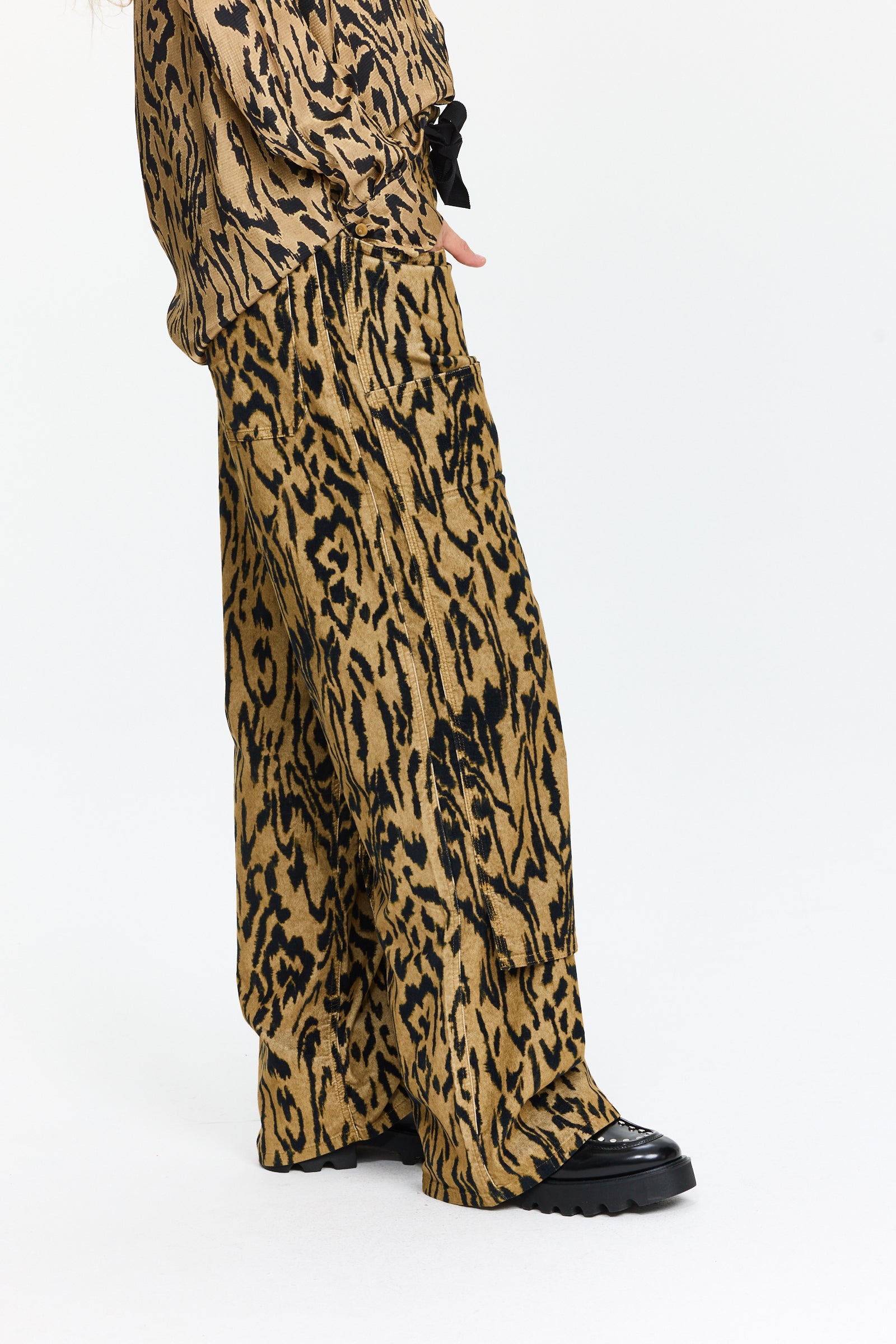 מכנסי קרגו מקטיפה עם הדפס שחור וטקסטורה עדינה.בעלי גזרה רחבה, כיסים צדיים, מותן עם גומי ושרוך קשירההרכב: 97% כותנה, 3% אלסטןהדוגמנית בגובה 1.75 ולובשת מידה 0 של Forte Forte