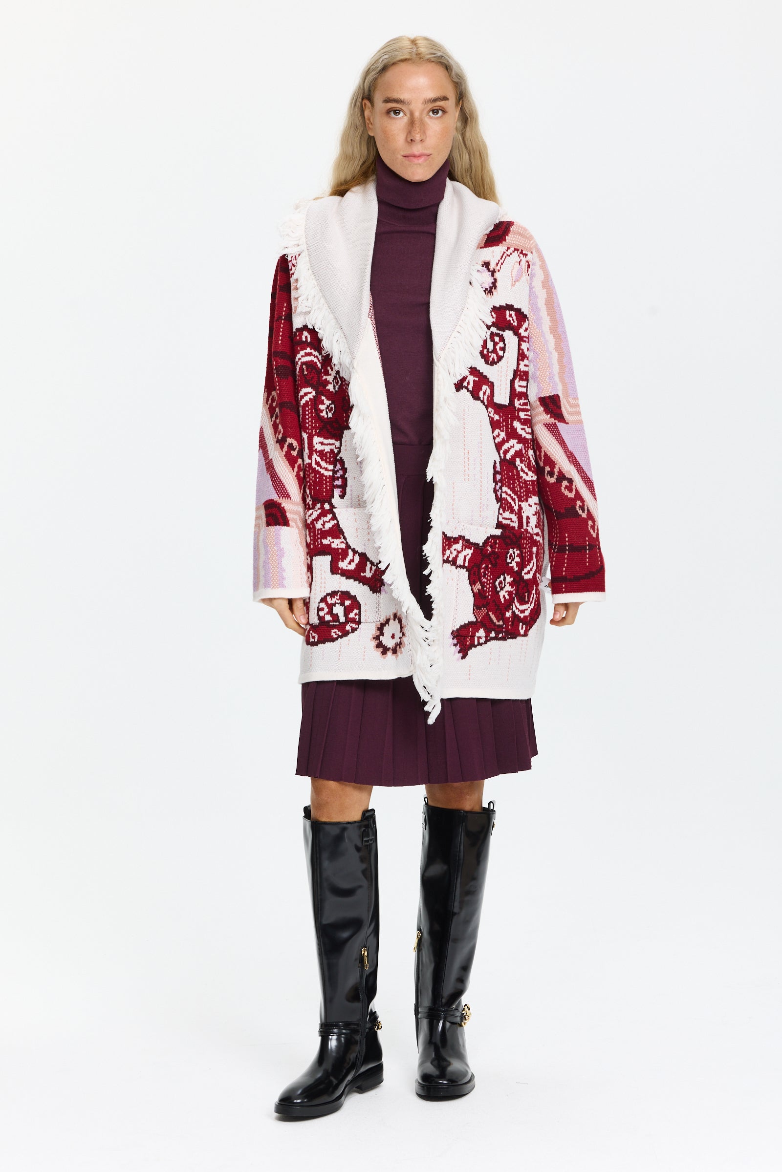 קרדיגן ארוך בסריג ג’קארד, עם כיסים קדמיים, חגורה תואמת, ופרנזים בקצה הרכב בד: 100% צמר מרינוהדוגמנית בגובה 1.75 ולובשת מידה M של Hayley Menzies