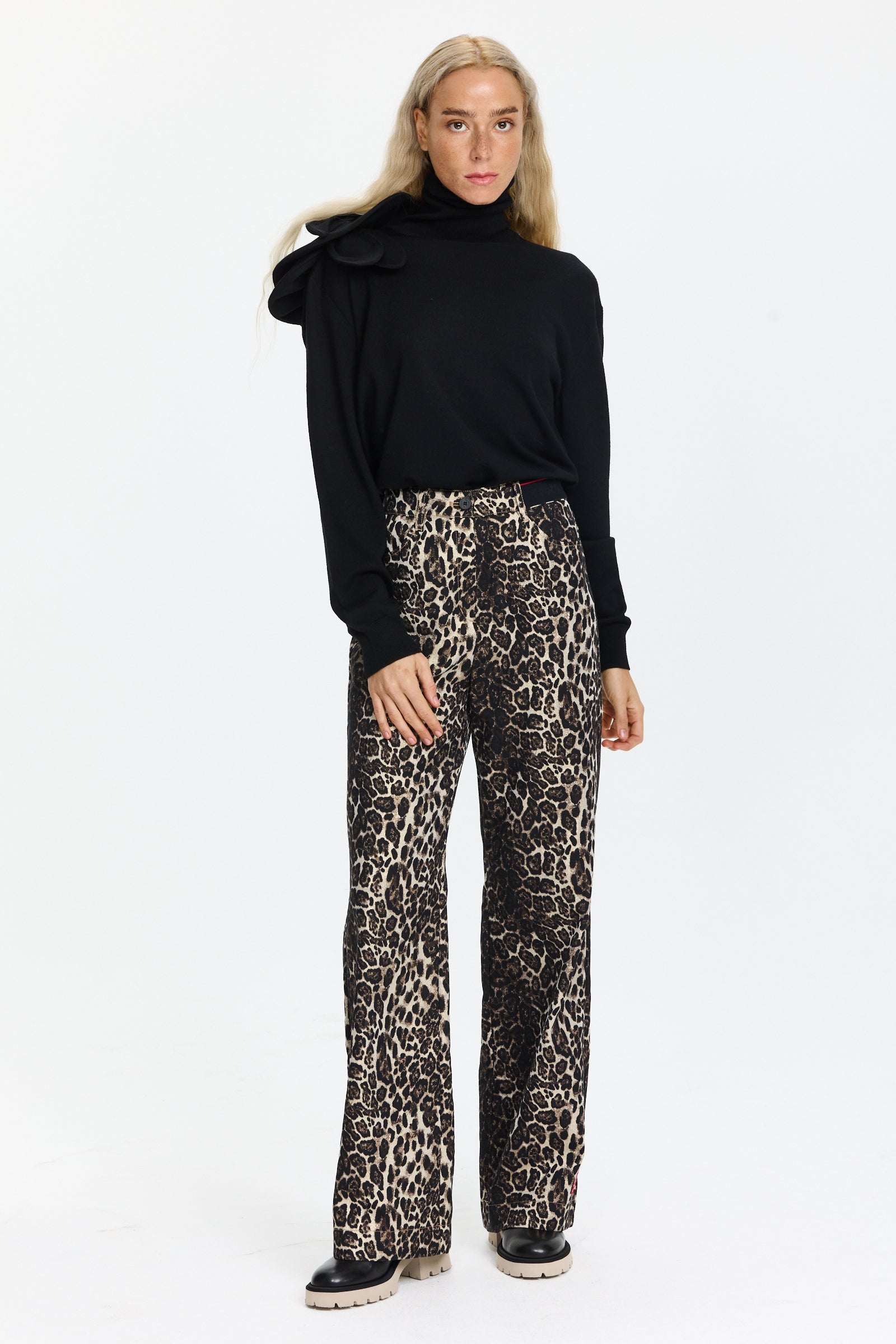 סריג גולף בגזרה צמודה, עם עיטור פרח בכתףהרכב: 100% צמר בתוליהדוגמנית בגובה 1.75 ולובשת מידה 42 של MOSCHINO