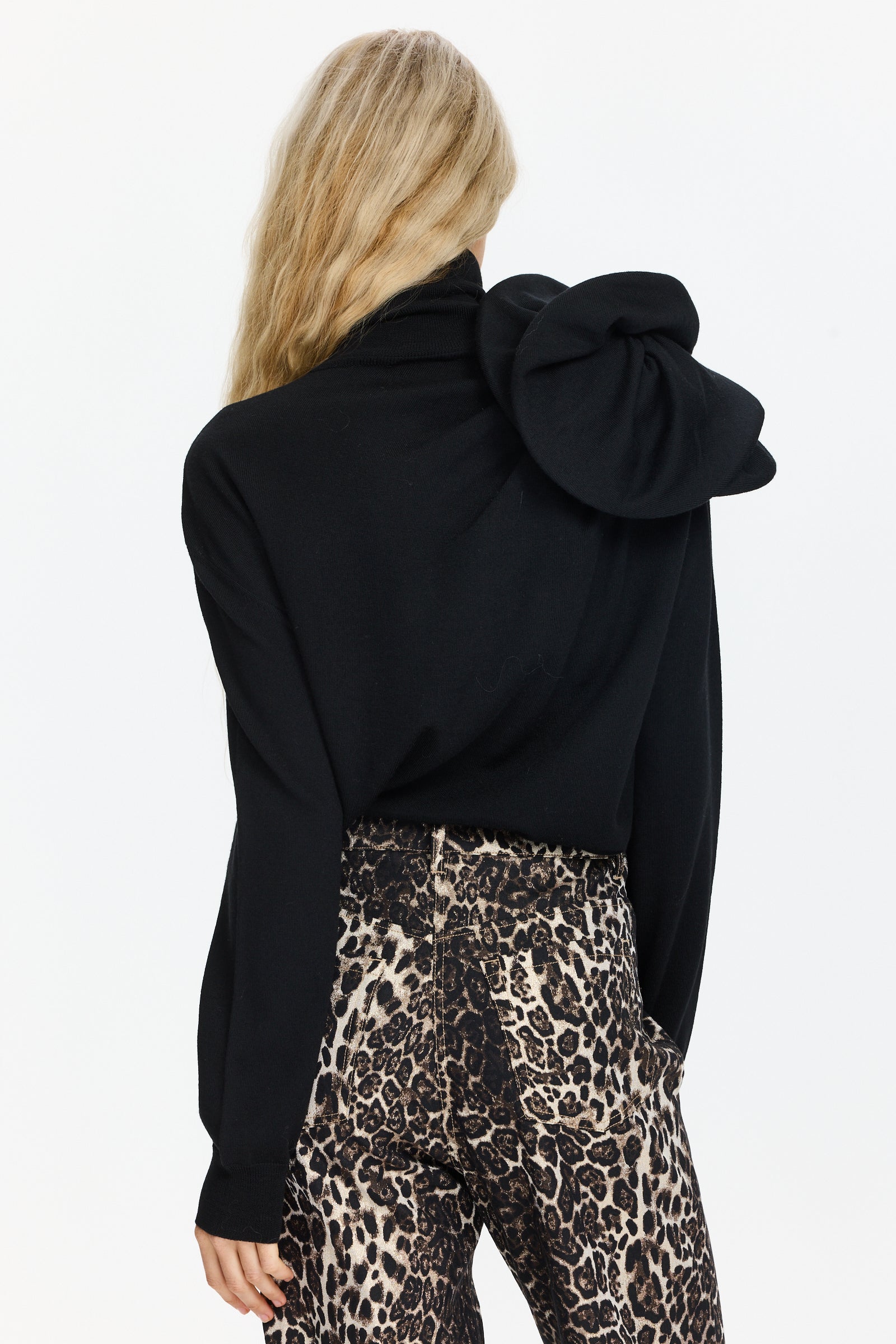 סריג גולף בגזרה צמודה, עם עיטור פרח בכתףהרכב: 100% צמר בתוליהדוגמנית בגובה 1.75 ולובשת מידה 42 של MOSCHINO