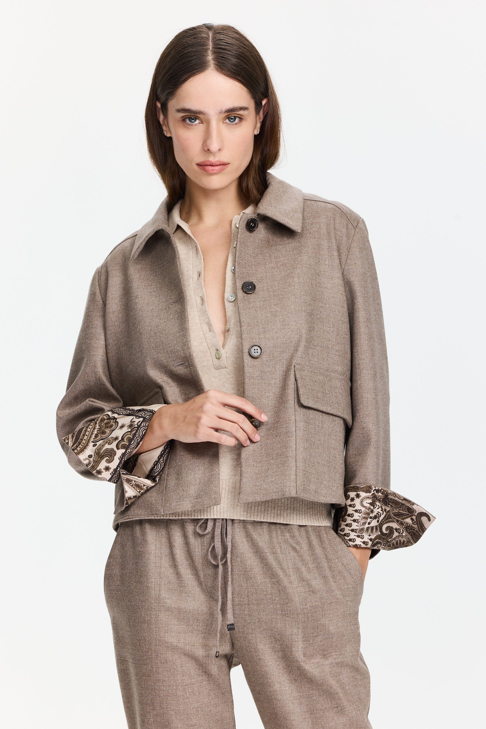 ז'קט צמר בגזרה קלאסית, עם סגירת כפתורים קדמית ותפרים נקיים, בגוון חום אפרפרהרכב בד: 99% צמר, 1% אלסטןהדוגמנית בגובה 1.75 ולובשת מידה 42 של Lorena Antoniazzi